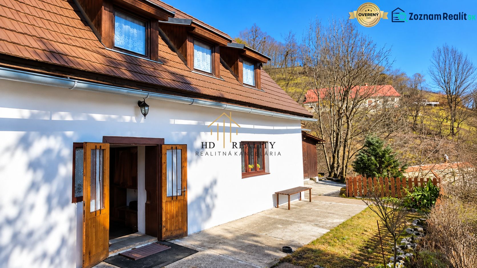A cottage in the picturesque Banská Štiavnica, surrounded by hills and a blue sky.