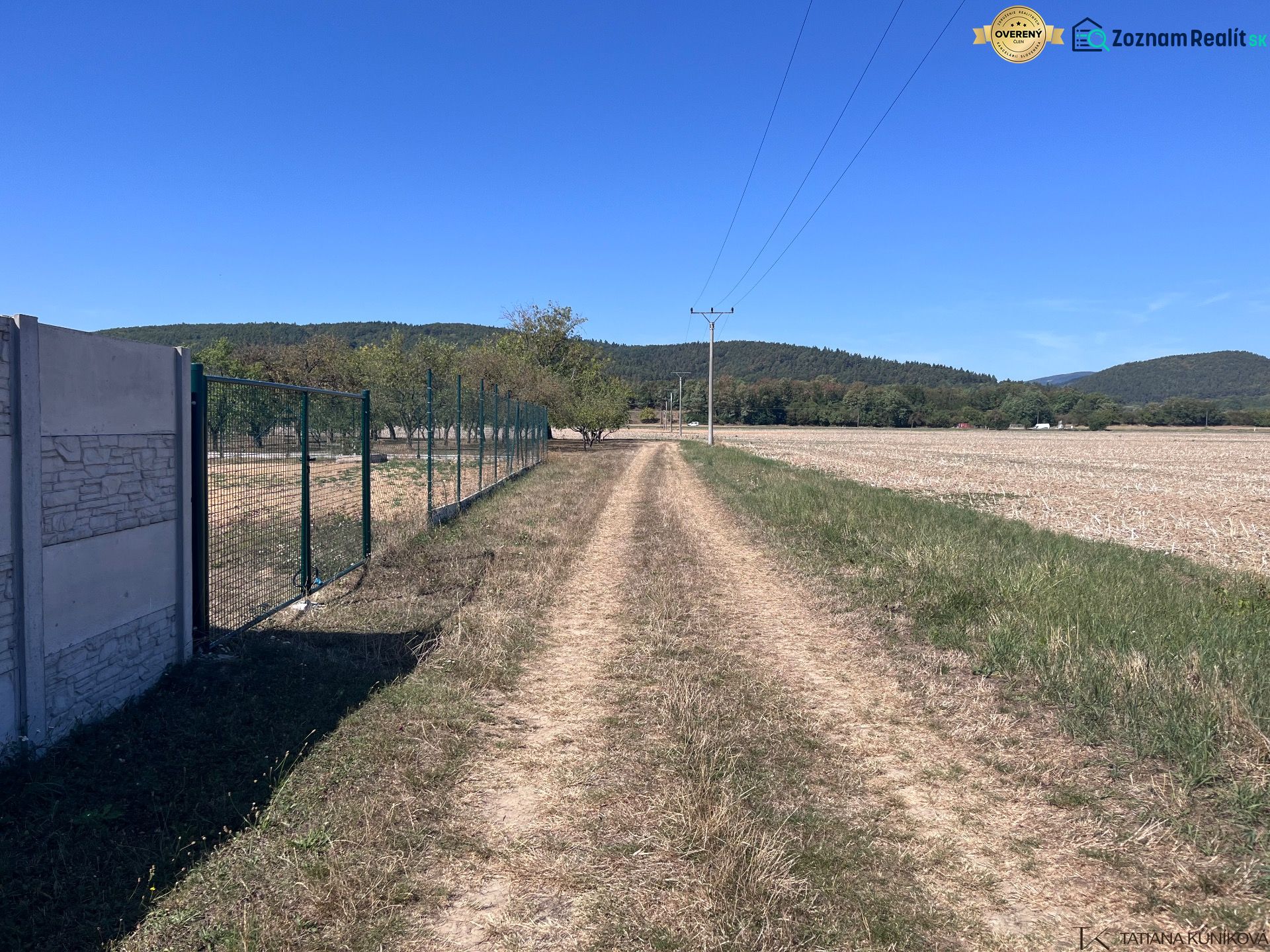 A dirt road in Dulov next to a fence and a large plot, ideal for living.