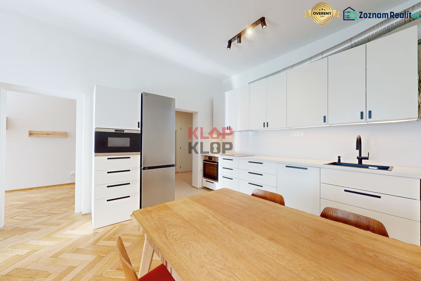 A kitchen in a 4-room apartment with white cabinets and a wood-patterned floor.