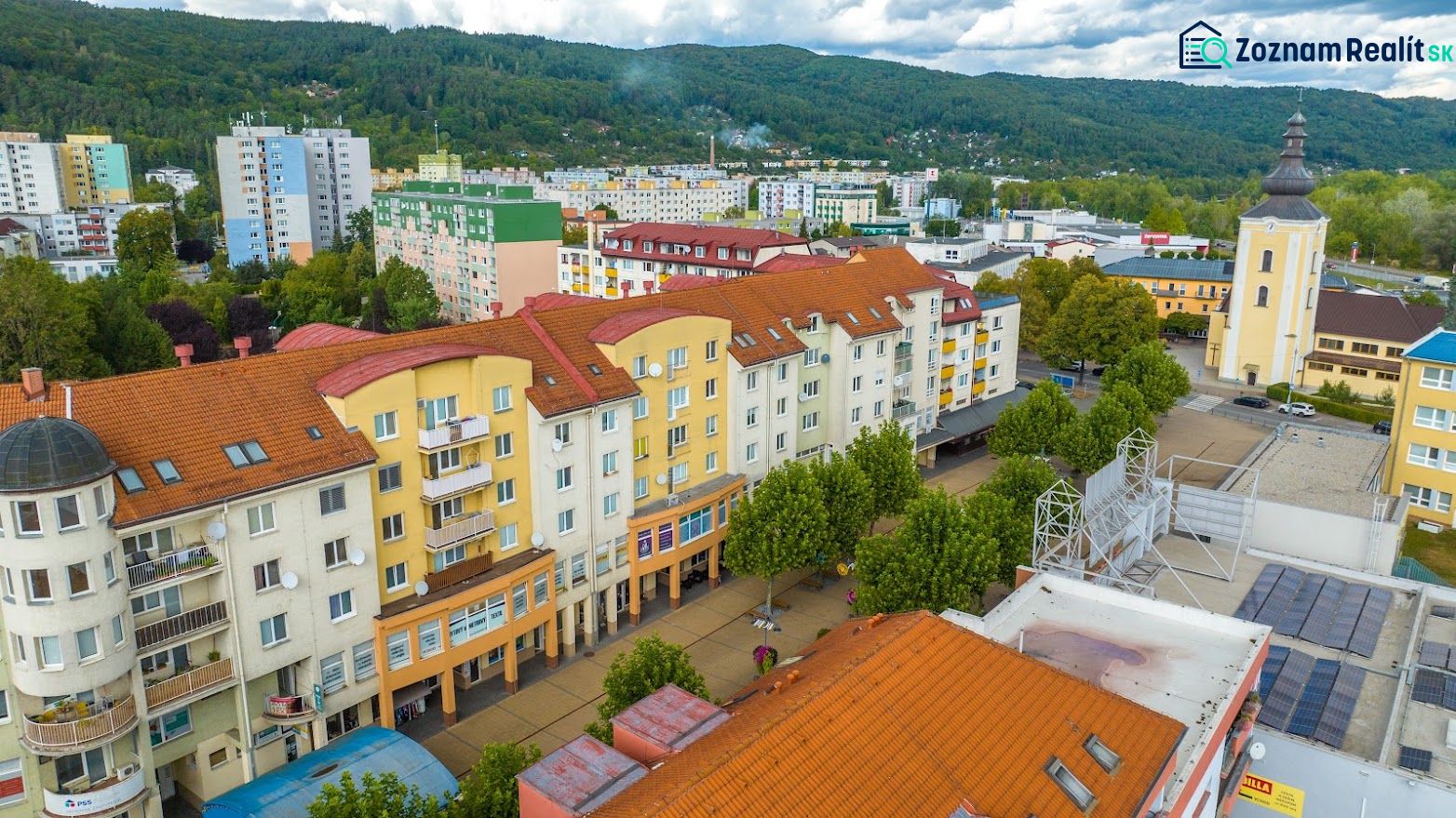 The commercial premises on Moyzesova Street in Púchov are surrounded by trees and buildings.