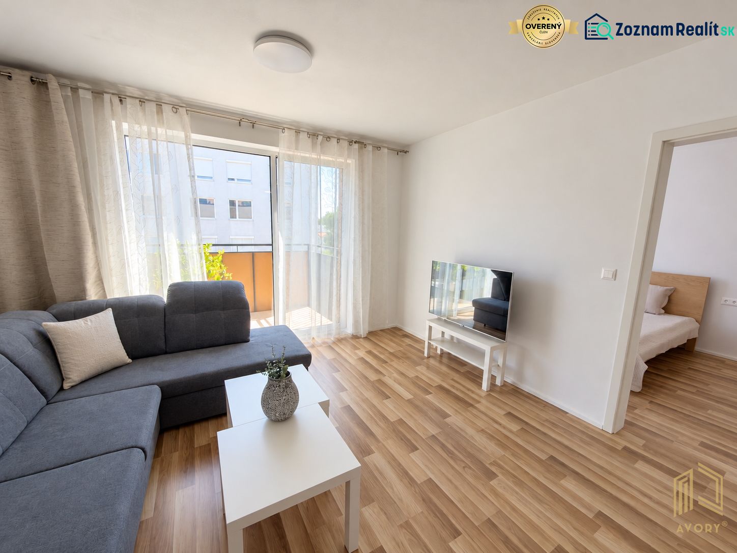 Living room in a two-room apartment with a wooden decor floor and a comfortable sofa.