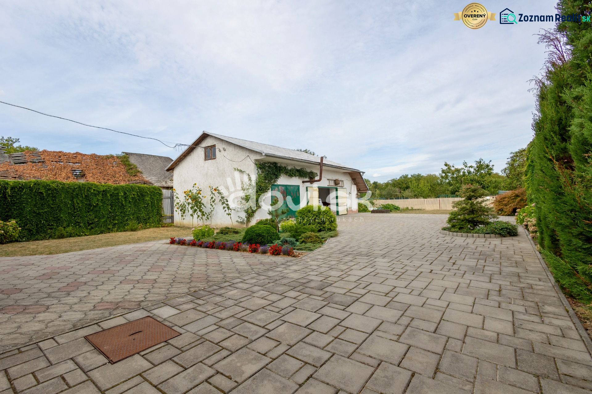 A family house on Topolianska Street in Michalovce with a paved yard and a neat hedge.