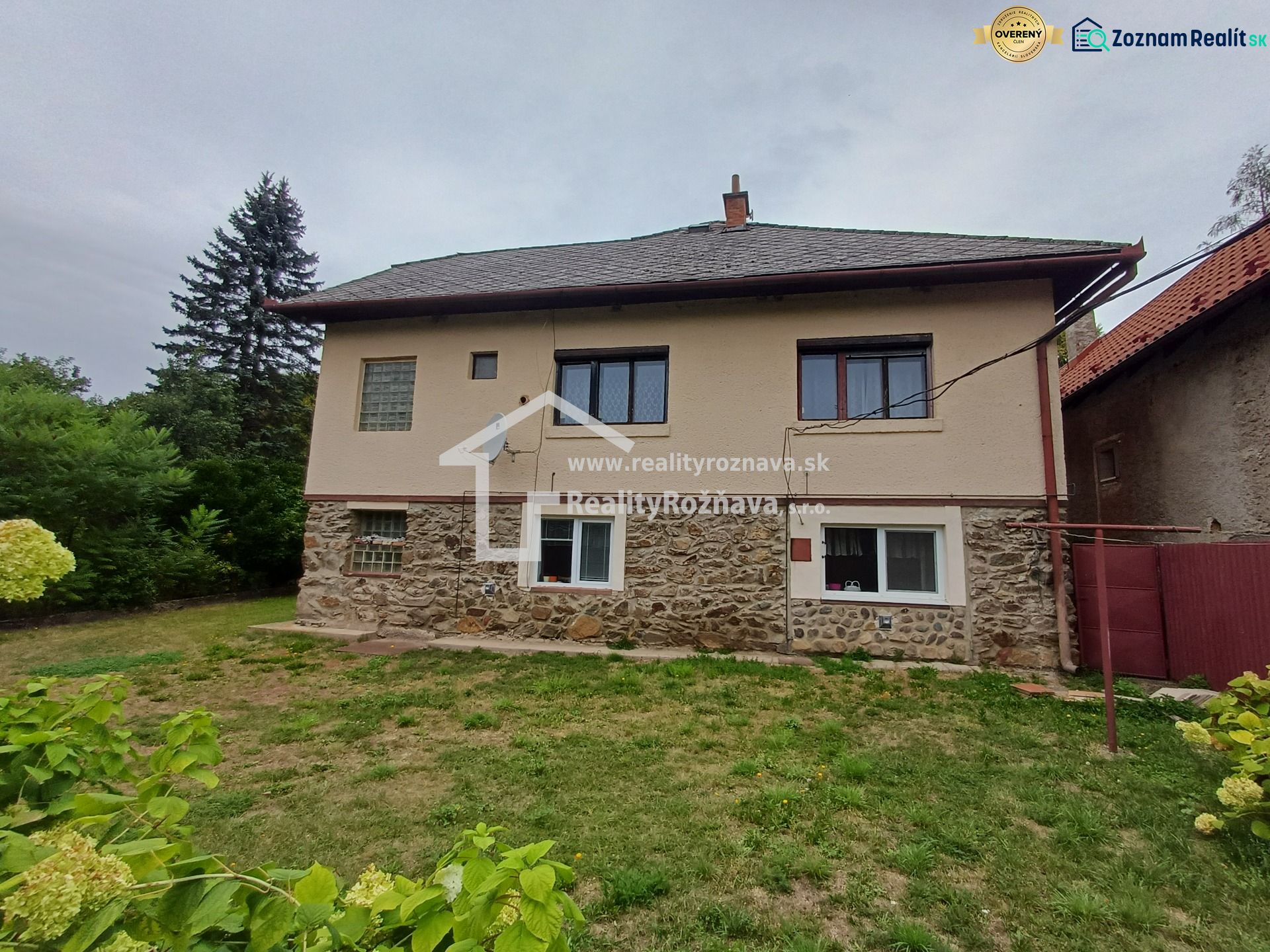 A family house in Drnava with a stone facade and a grassy garden in a fresh environment.