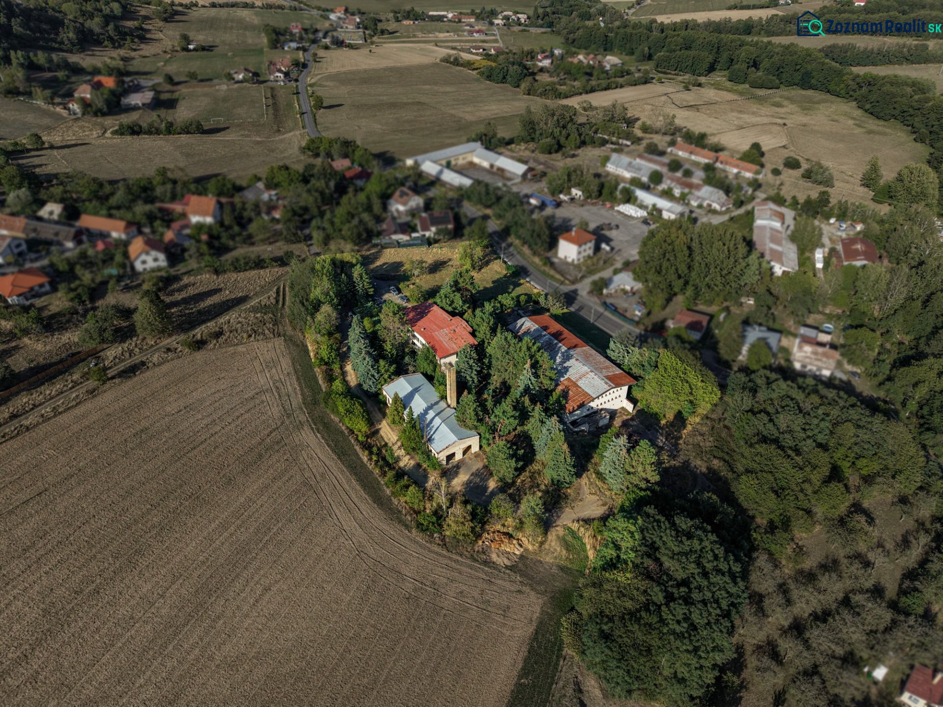 Development plots in Slatinské Lazy surrounded by fields and greenery.
