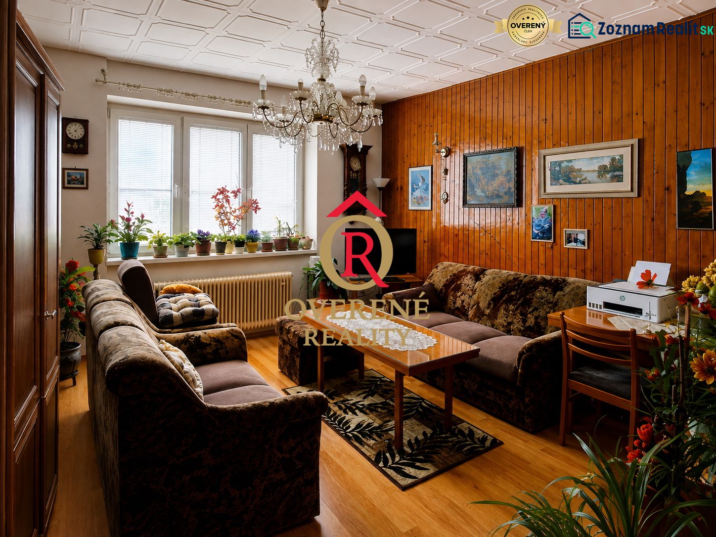 Living room in a family house with sofas and plants, wooden decor flooring.