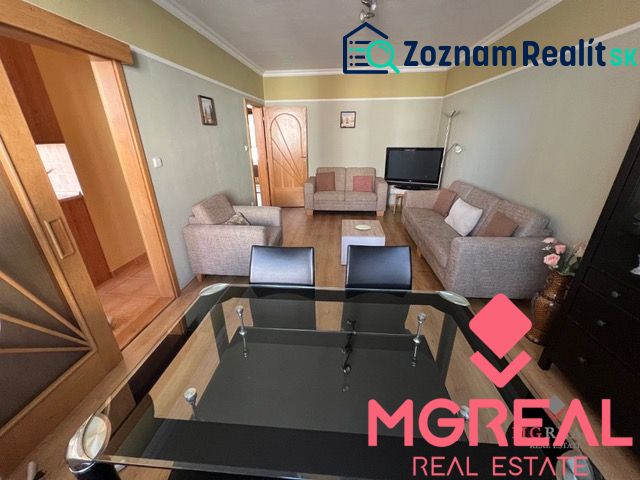 Living room in a three-room apartment with sofas and a glass table, floor with wood decor.