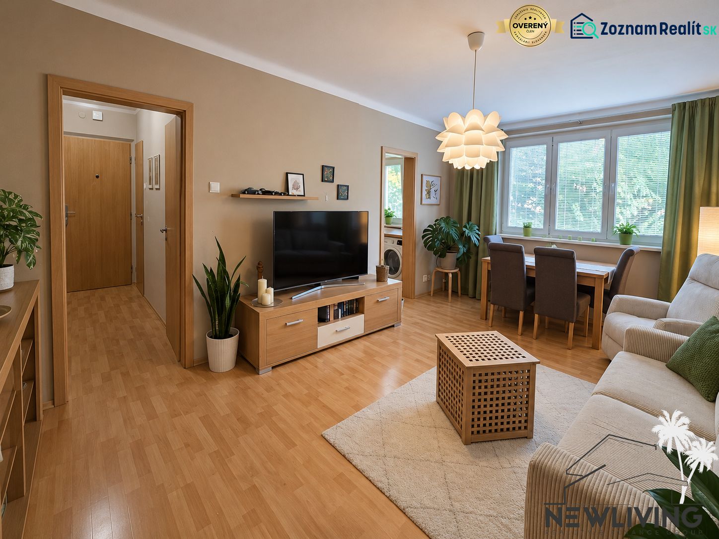 Living room in a three-room apartment with a wooden-patterned floor and a large window.
