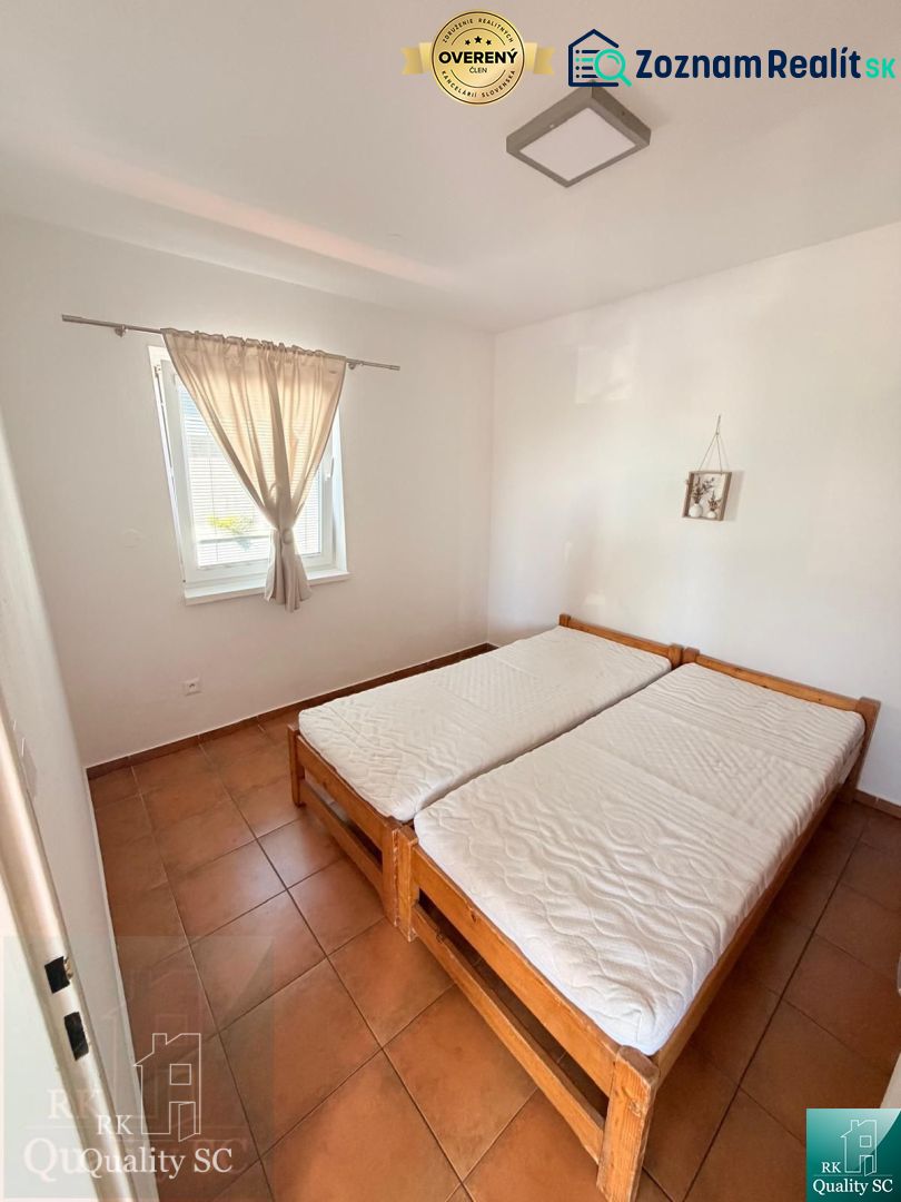 Bedroom in a one-room apartment with a double bed and tiles.