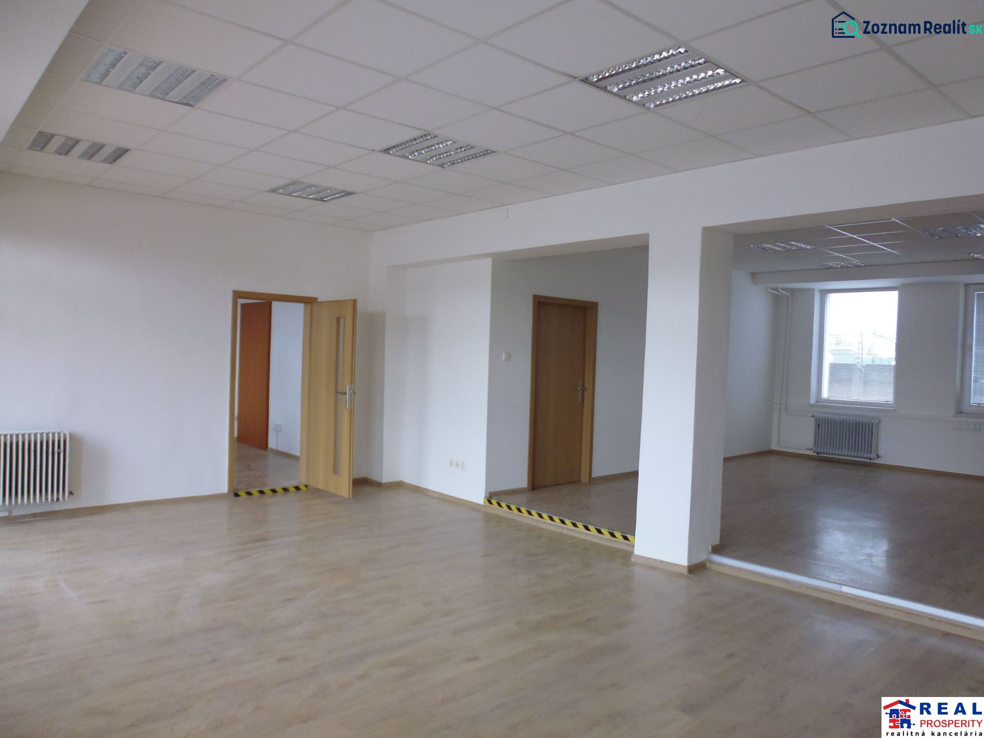 Interior of commercial spaces with wood-patterned flooring and white walls.