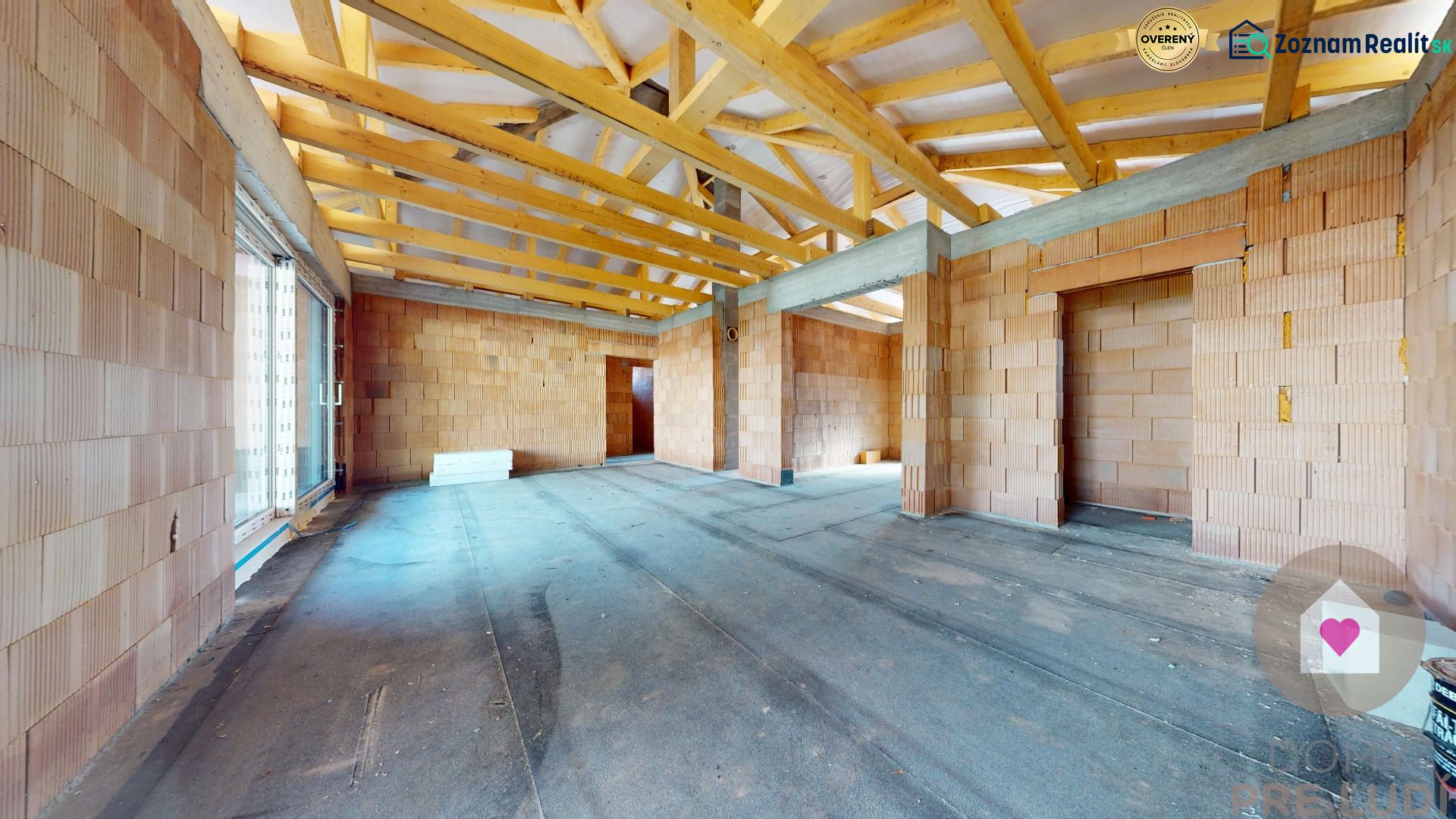 Unfinished interior part of a family house with visible wooden beams and brick walls.