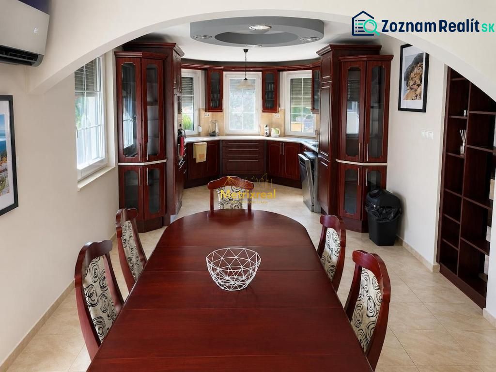A kitchen in a family house with wooden furniture and a dining table.