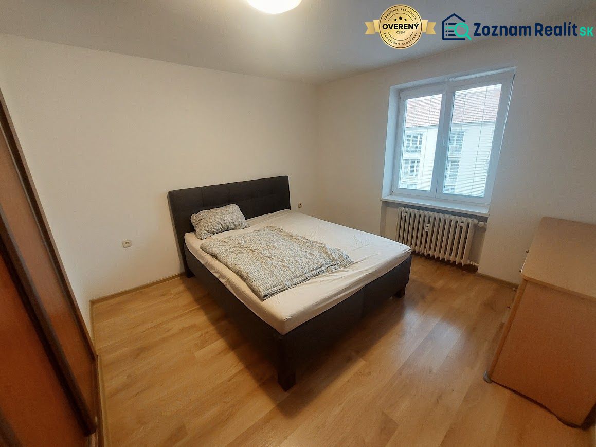 Bedroom with a bed and wooden decor flooring in a two-room apartment.