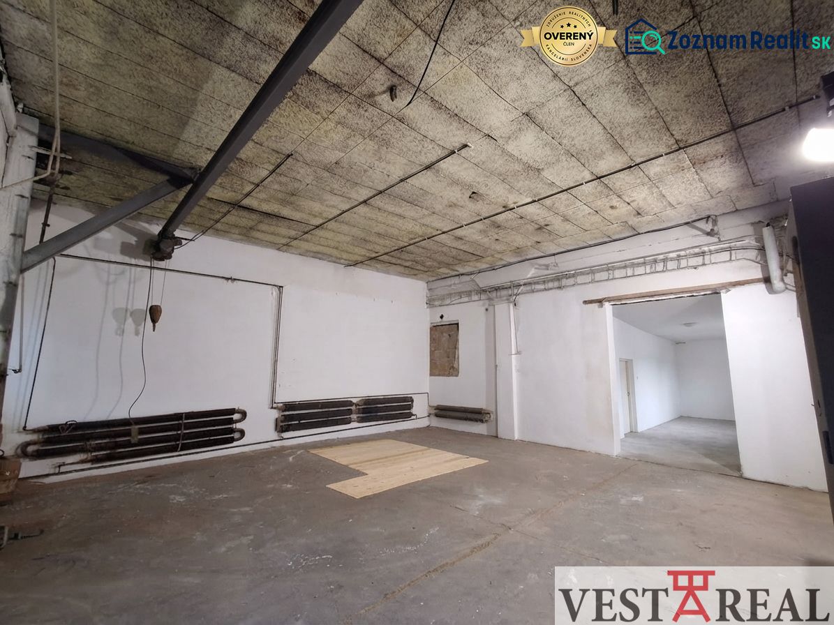 Space in the warehouse on Niklova Street in Sereď with exposed piping and a panel ceiling.