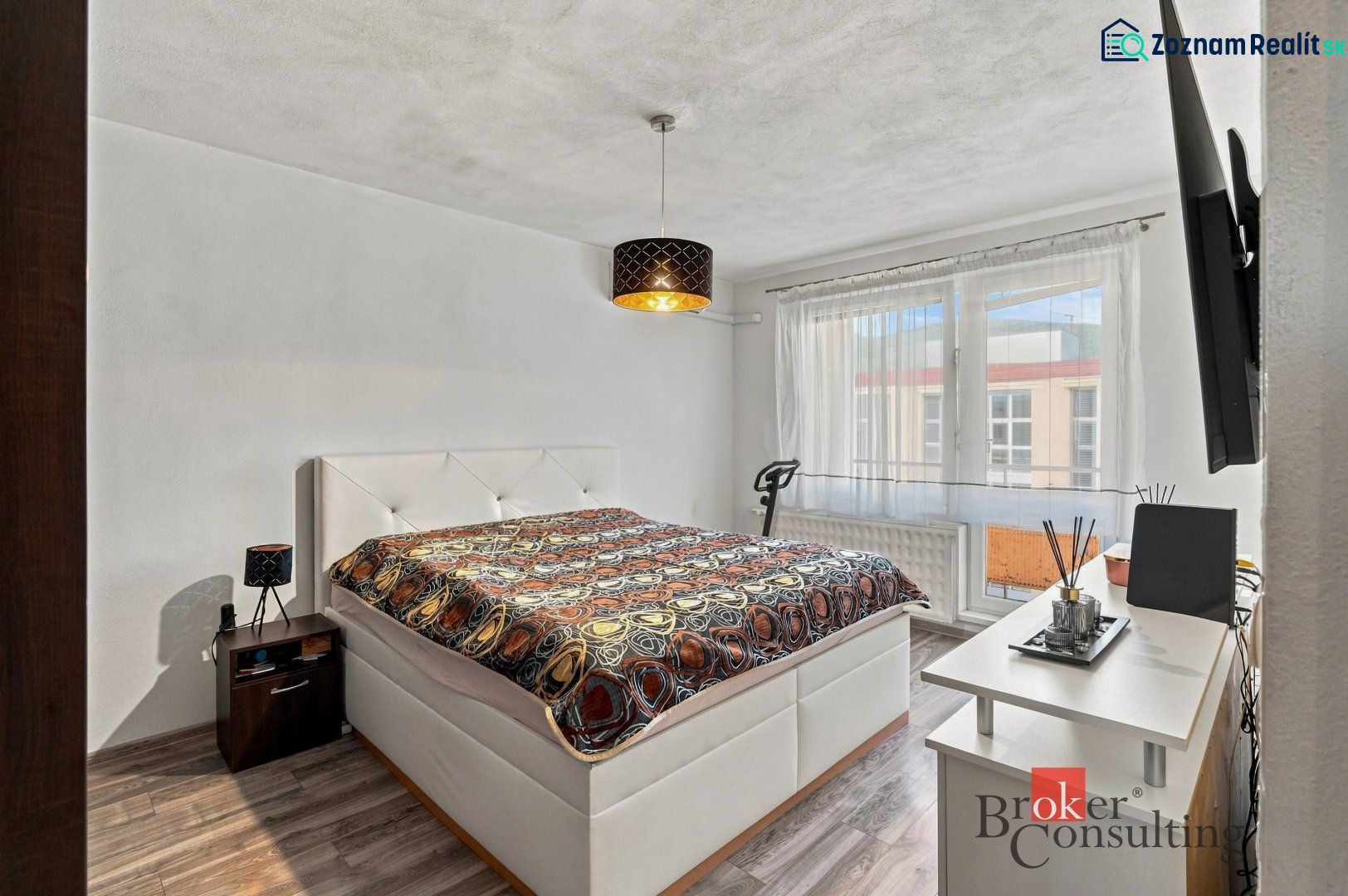 Dining area with a table and chairs in a 2-room apartment with a wooden decor floor.