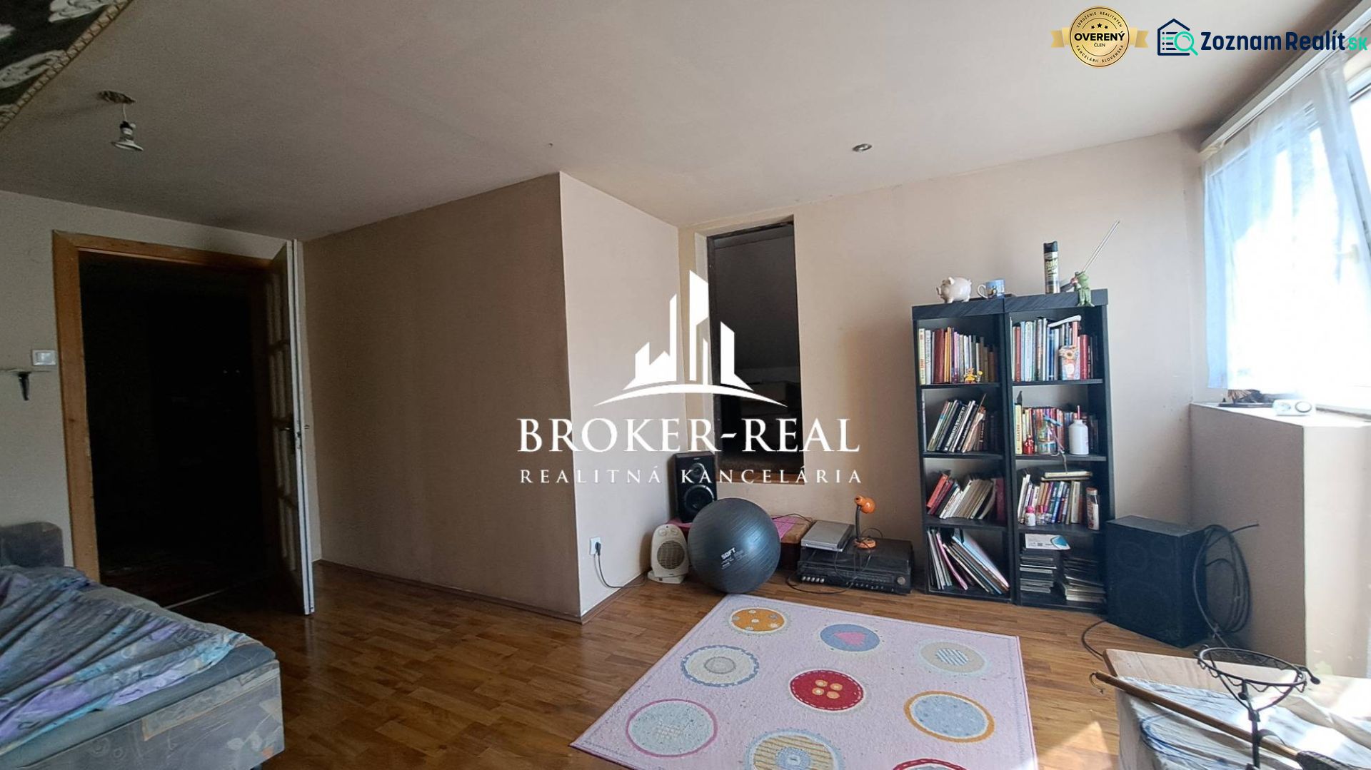 Living room in a cottage with a wooden decor floor and a bookshelf.