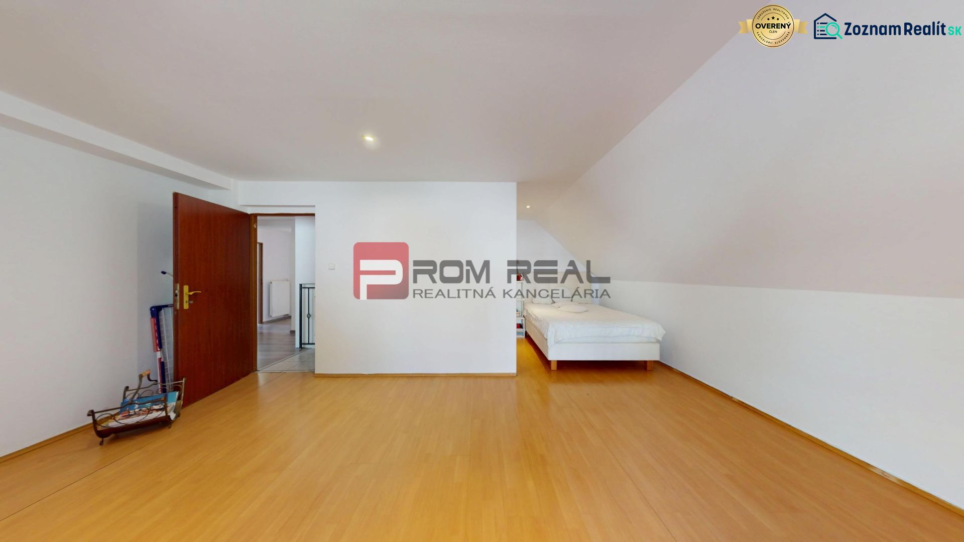 A bedroom in a family house with a wooden decor floor and white furniture.