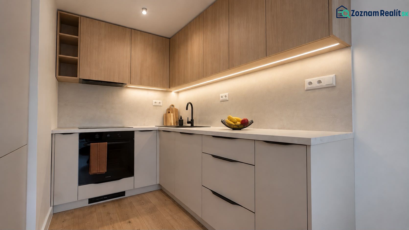 A kitchen in a 3-room apartment with wooden decor, minimalist cabinets, and recessed lighting.