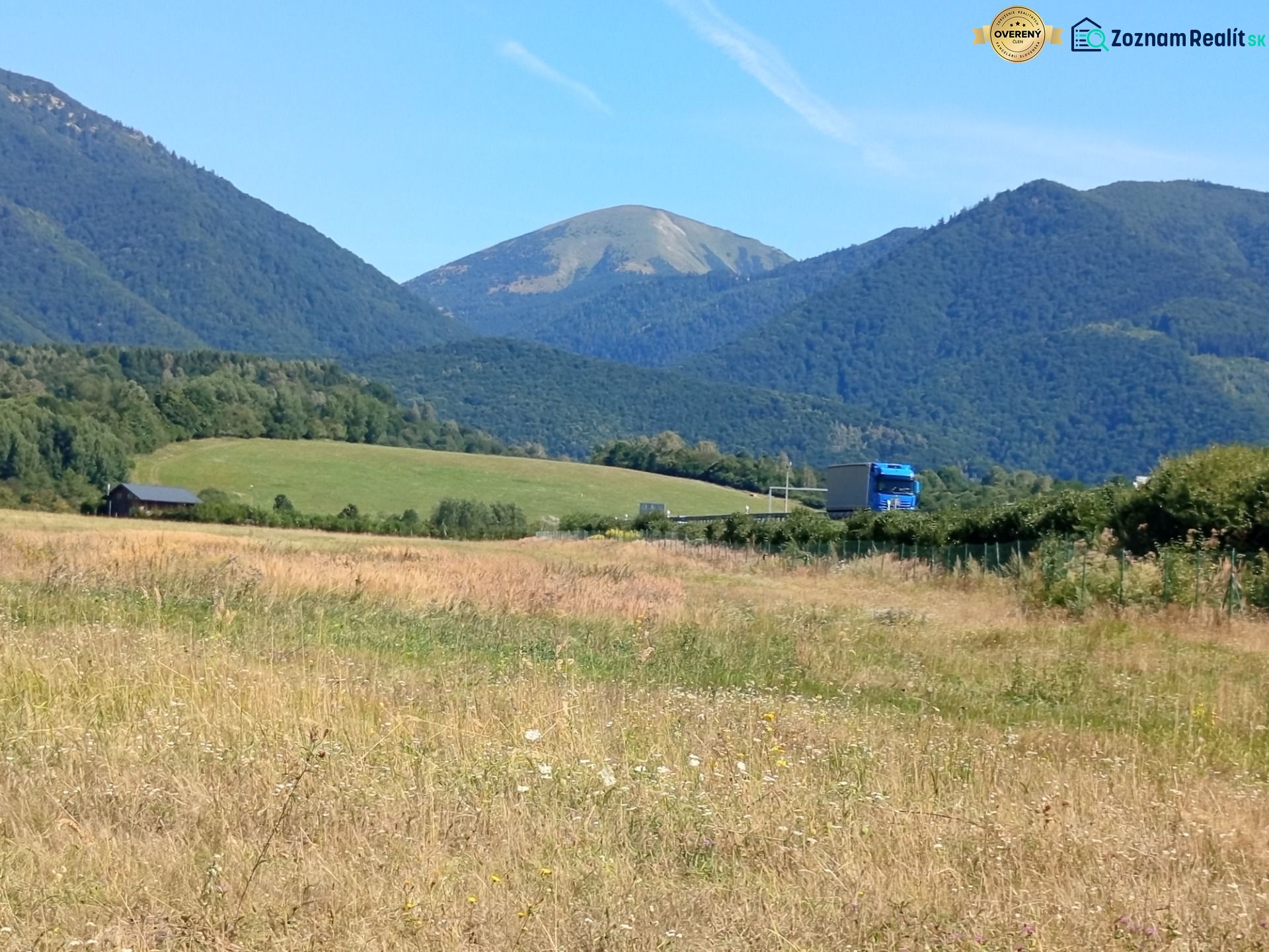Recreational lands near the town of Turany with a mountain range and a truck on the road.