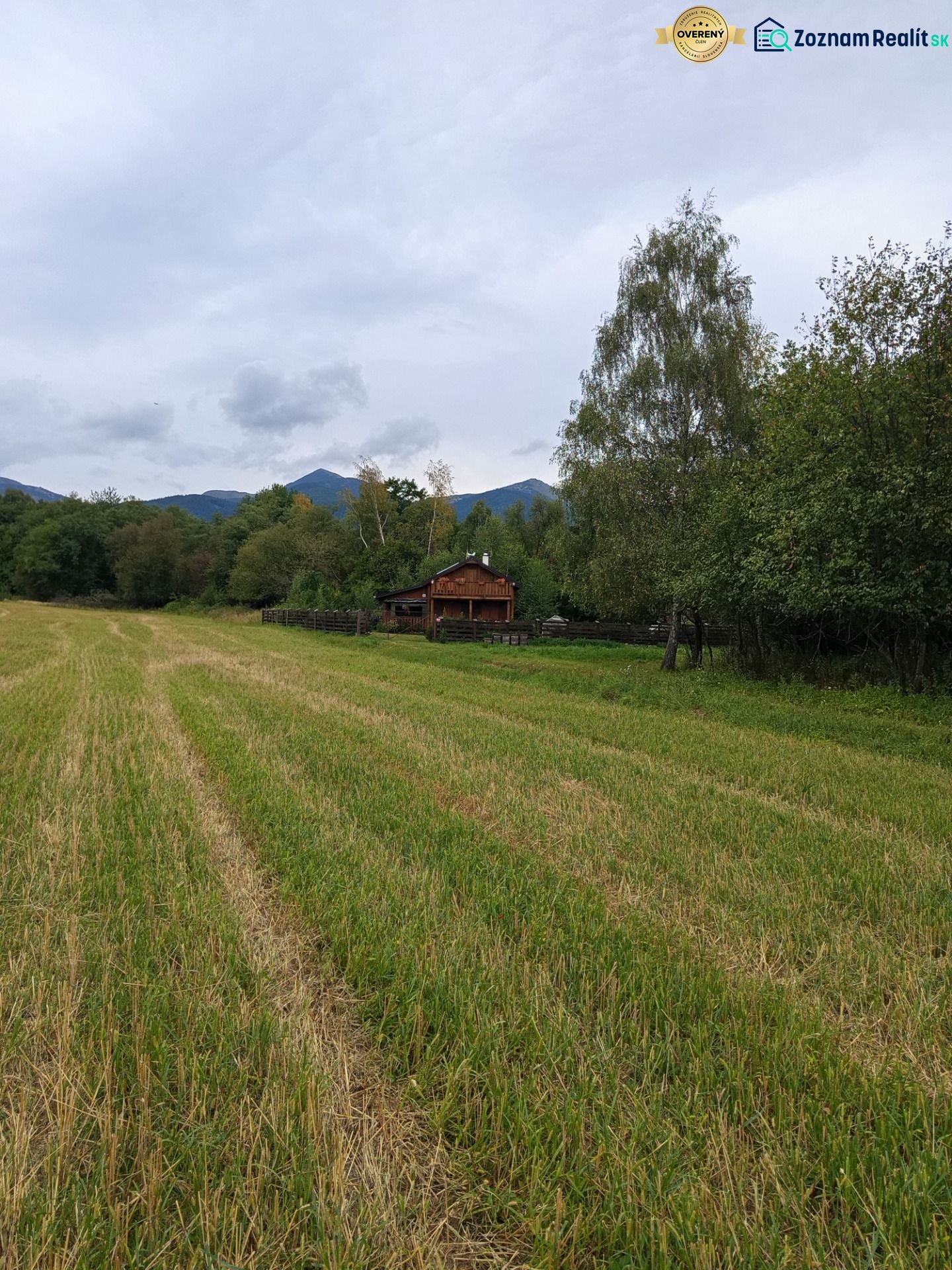 Recreational land in Turany with a wooden cottage, surrounded by nature and mountains.