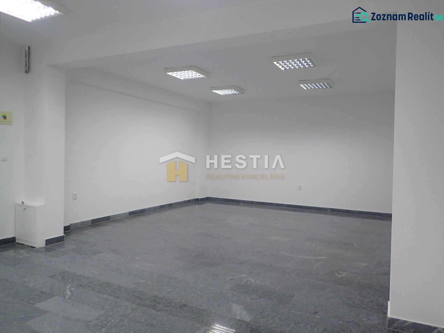 White room with tiling and built-in lighting, intended for commercial use.