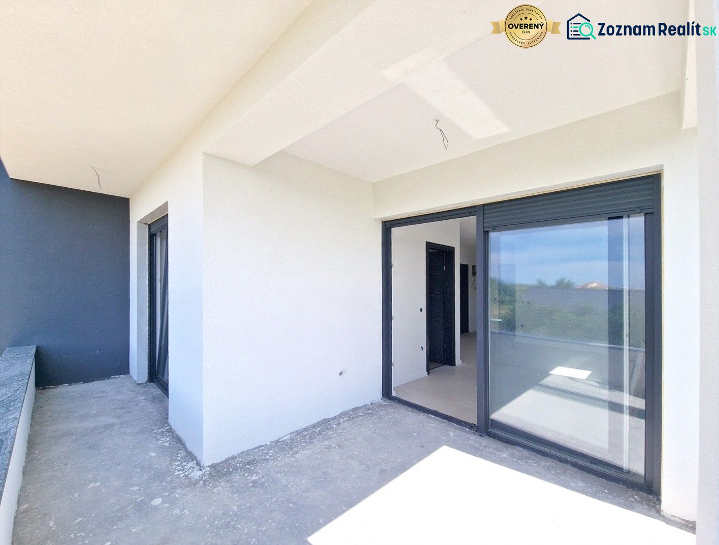 A balcony in a 3-room apartment in Privlaka with large sliding windows.