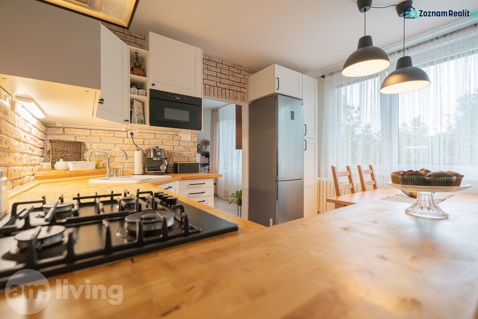 A kitchen in a 3-room apartment with brick cladding and a wooden decor floor.
