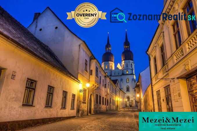 A historic alley in Trnava with a cathedral in the background, ideal for living in a 2-room apartment.