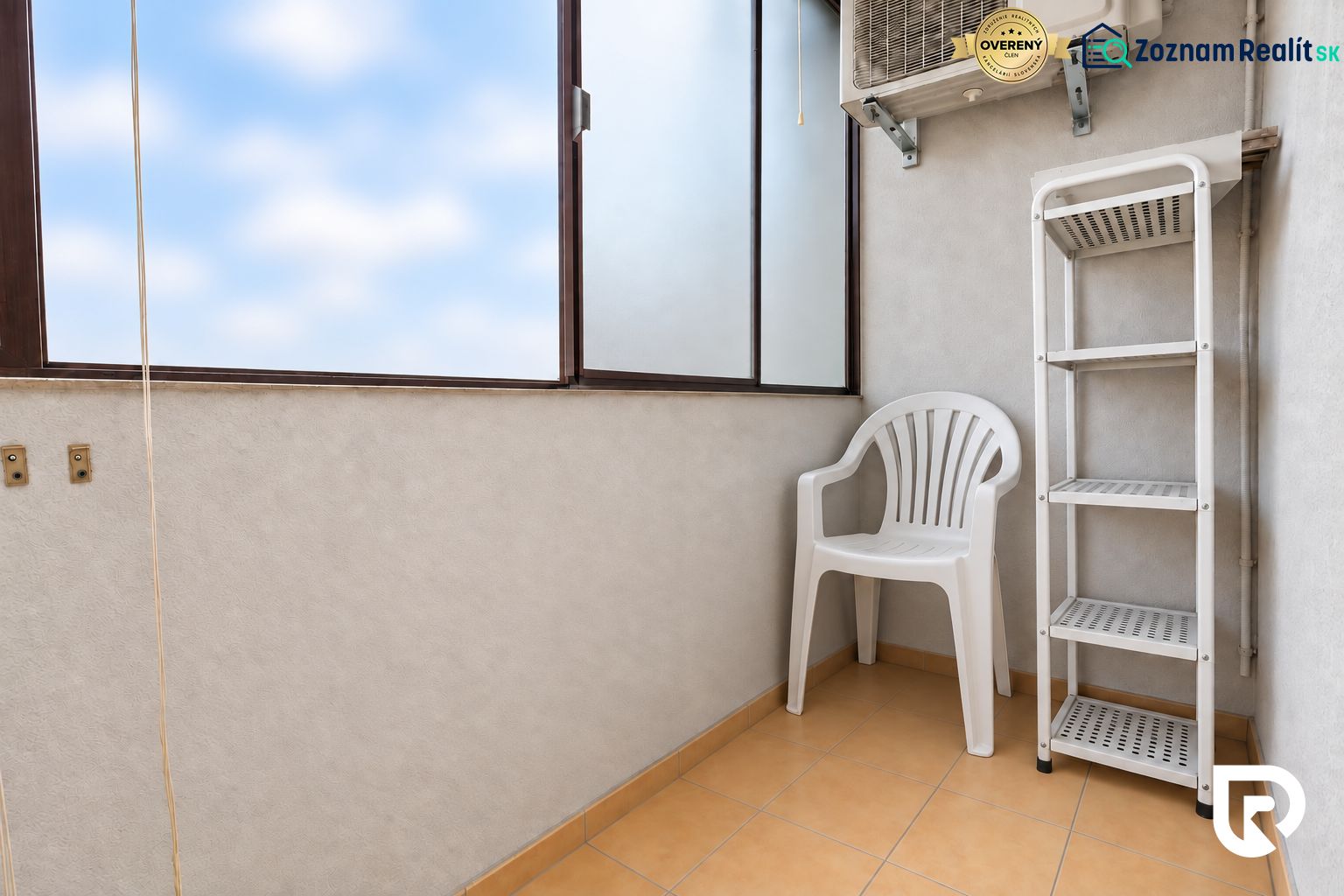 A balcony in a 3-room apartment with a plastic chair, a shelf, and air conditioning.