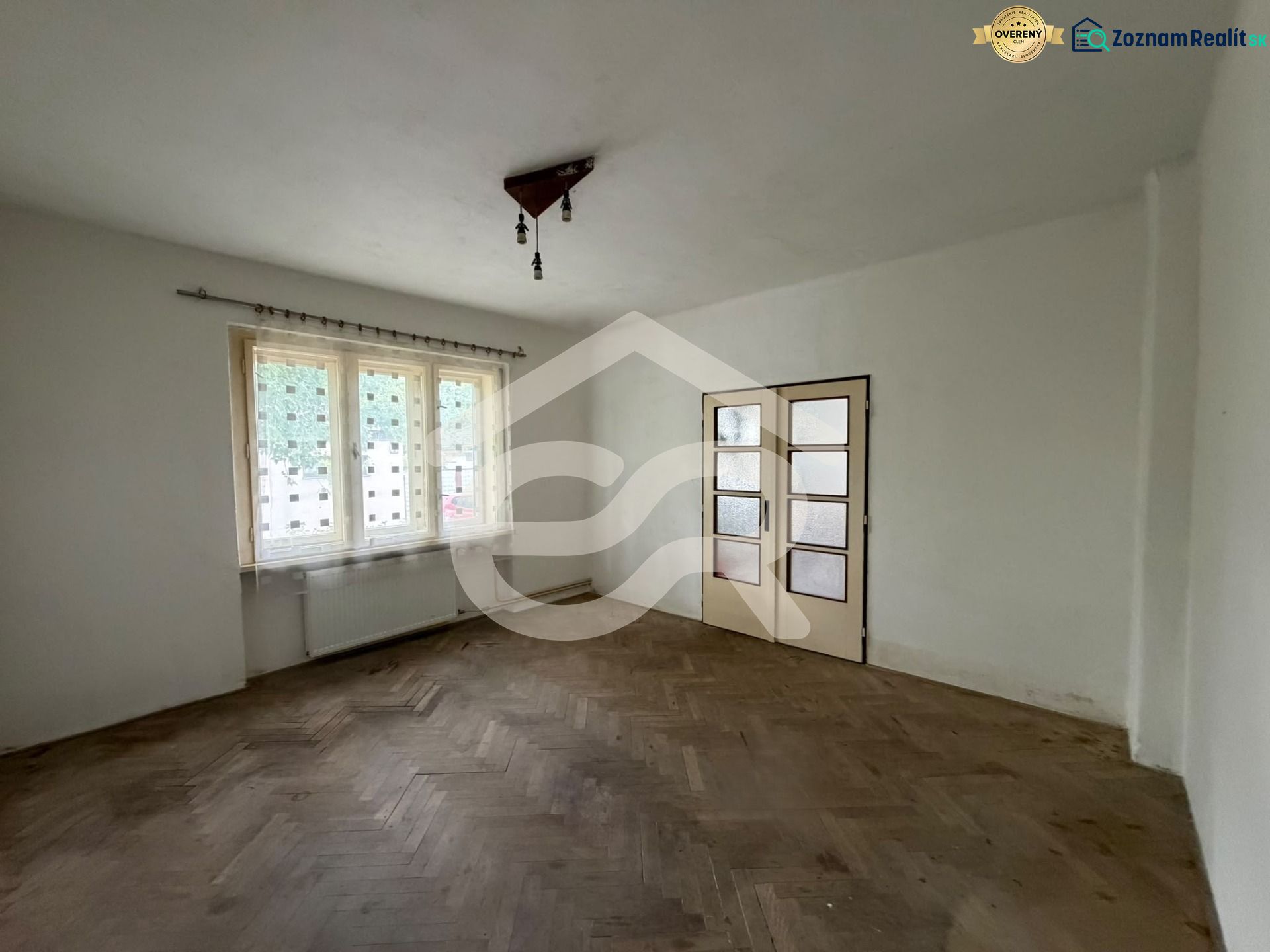 The interior of a family house with white walls and a floor with a wooden decor.