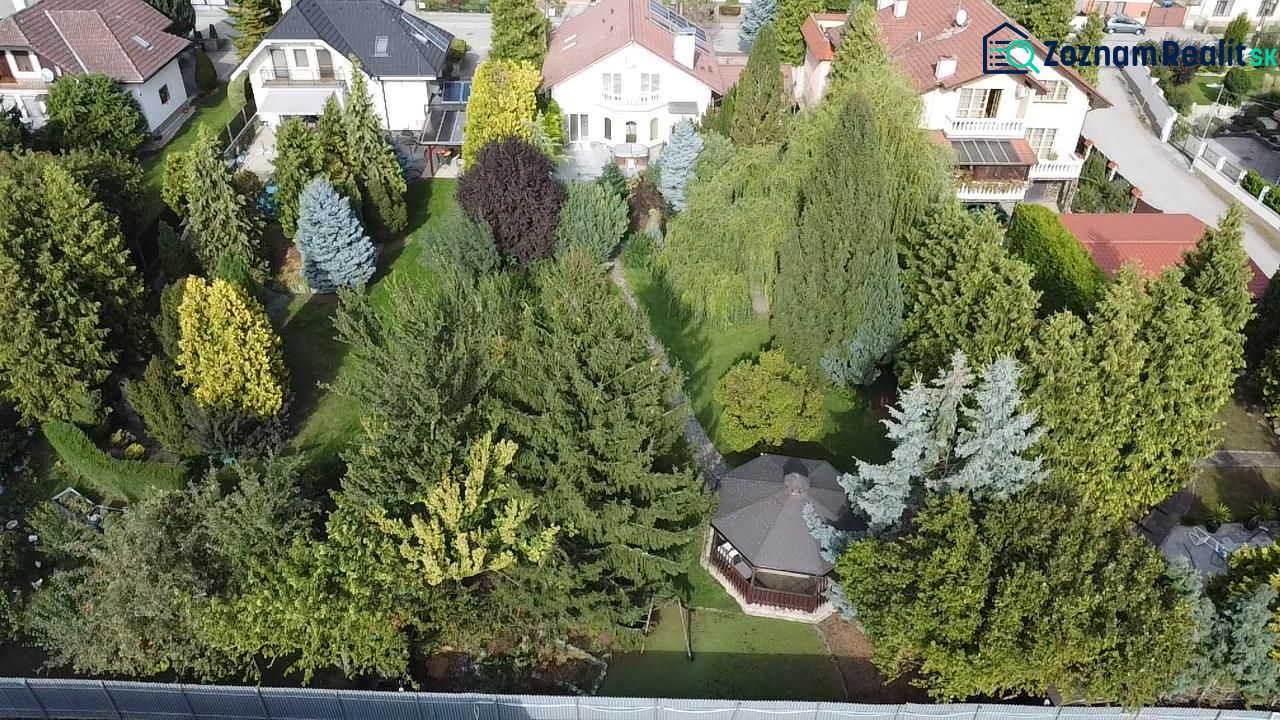Family houses in Trenčianske Stankovce surrounded by dense greenery and colorful trees.