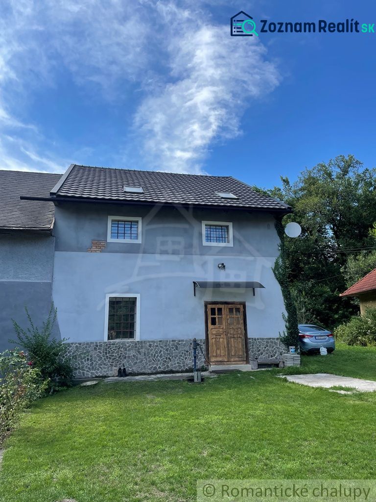 A family house in Mokrá Lúka with a stone facade and wooden doors.