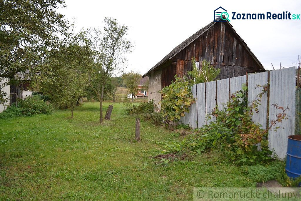A garden at a family house in Nemcovce with a wooden barn and green lawn.