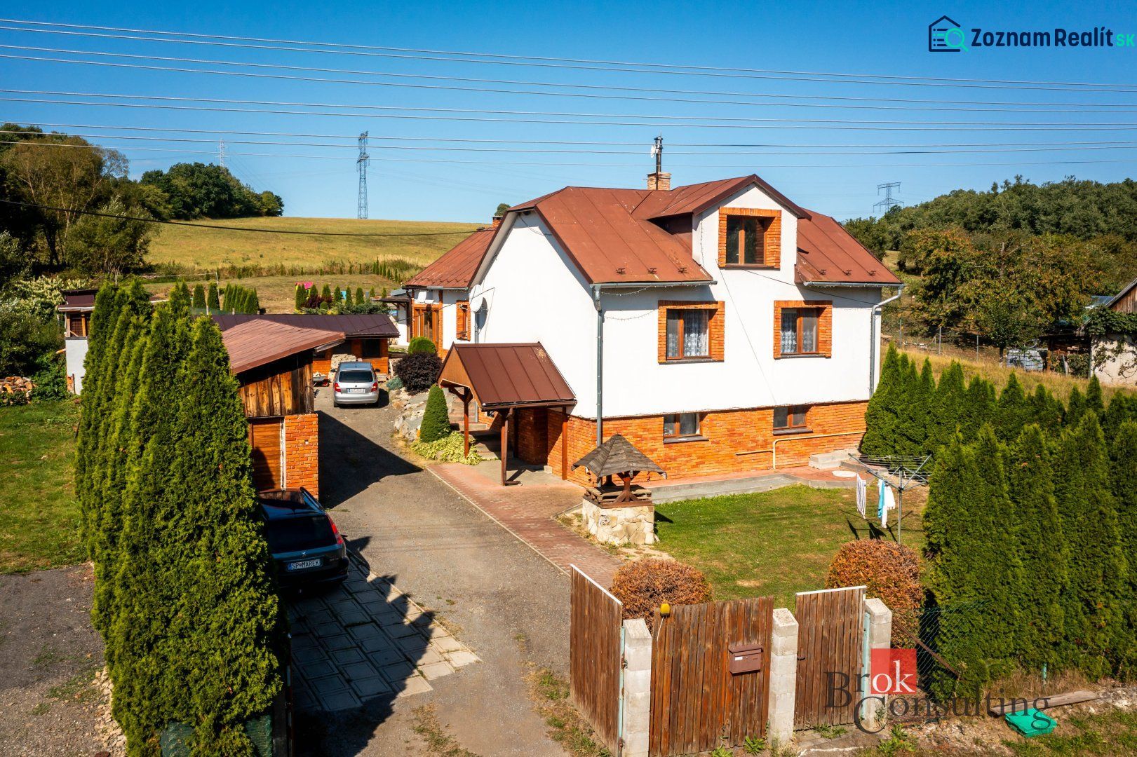 A family house in Potoky with two cars and a gate on a large plot.