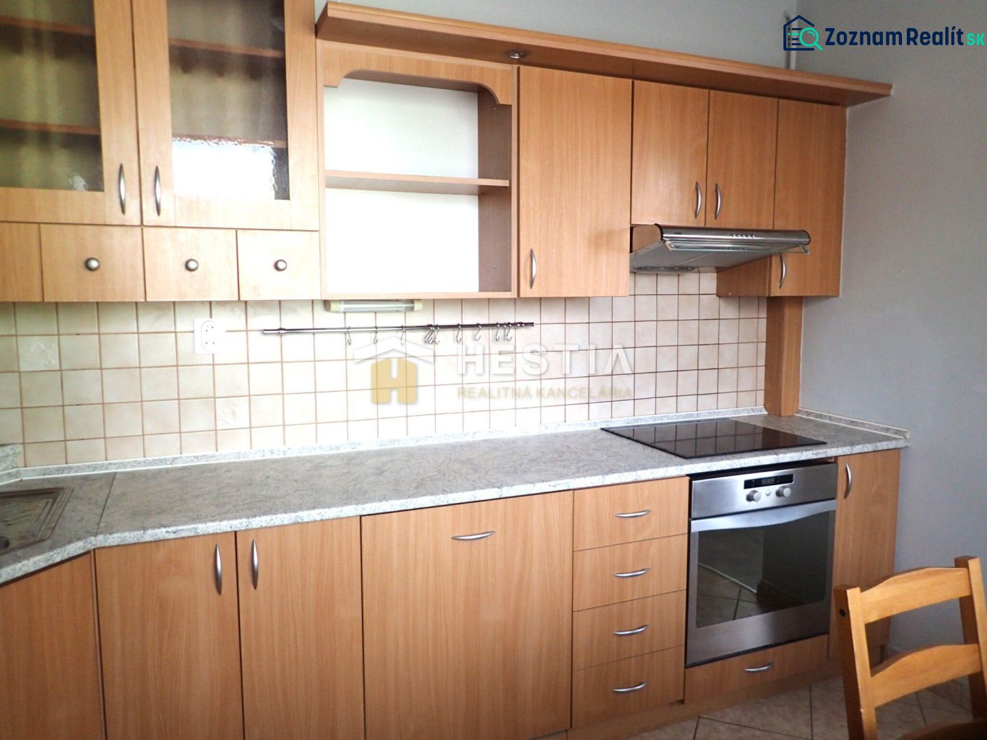A kitchen in a 3-room apartment with a wooden decor and built-in appliances.