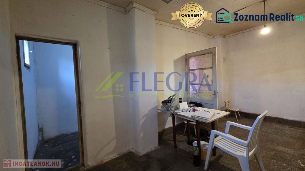 A room in a family house with a plastic chair and a simple table.