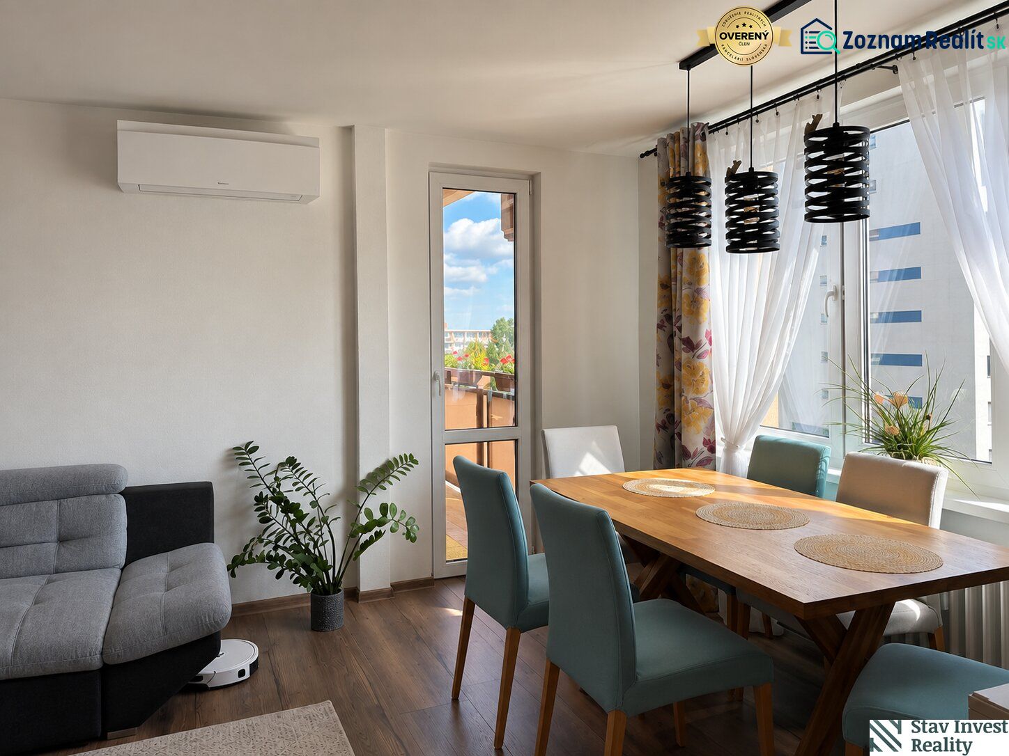 Dining room of a 3-room apartment with a wooden decor floor and a balcony.