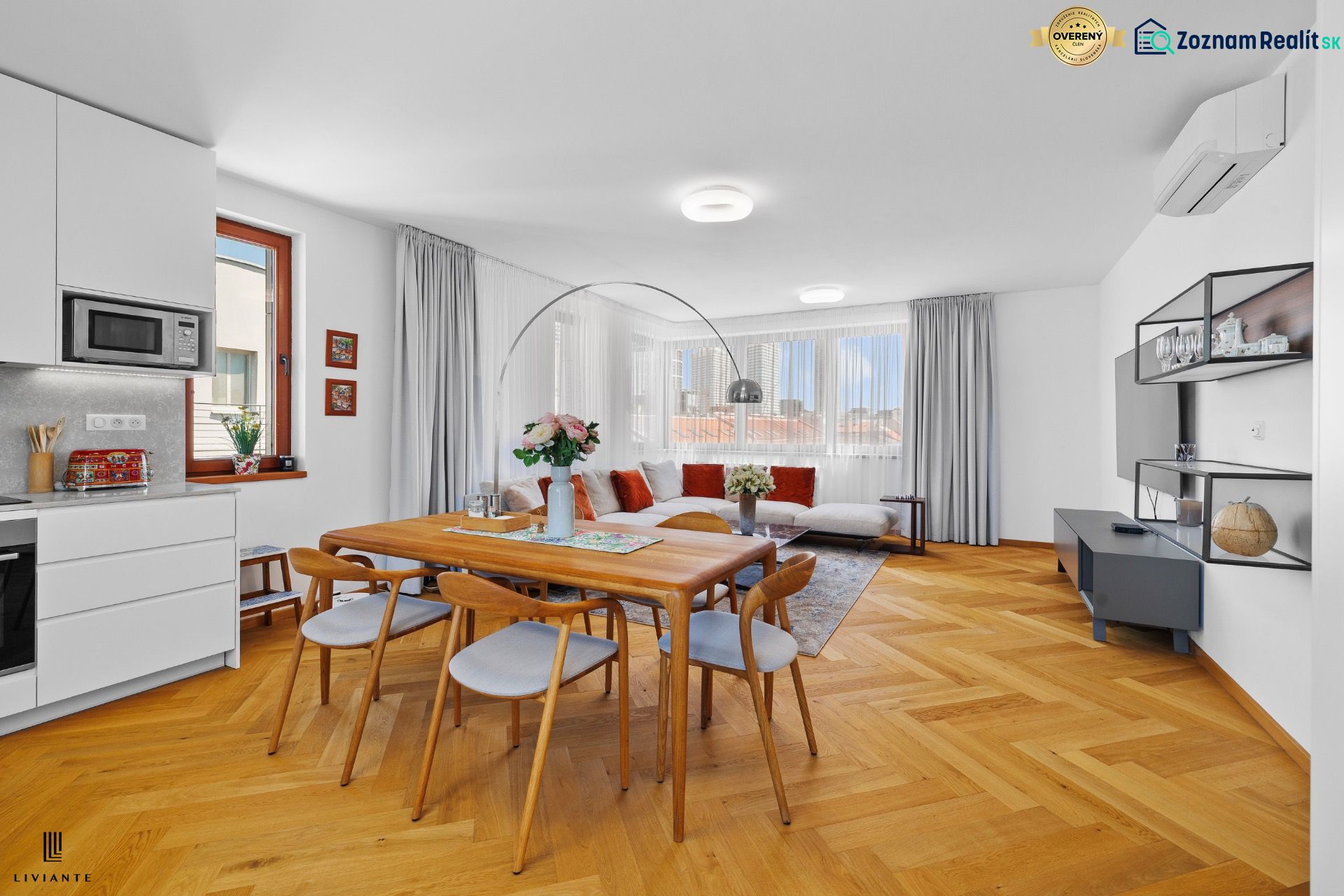 Living room with a kitchenette, dining table, and wooden decor flooring in a 3-room apartment.
