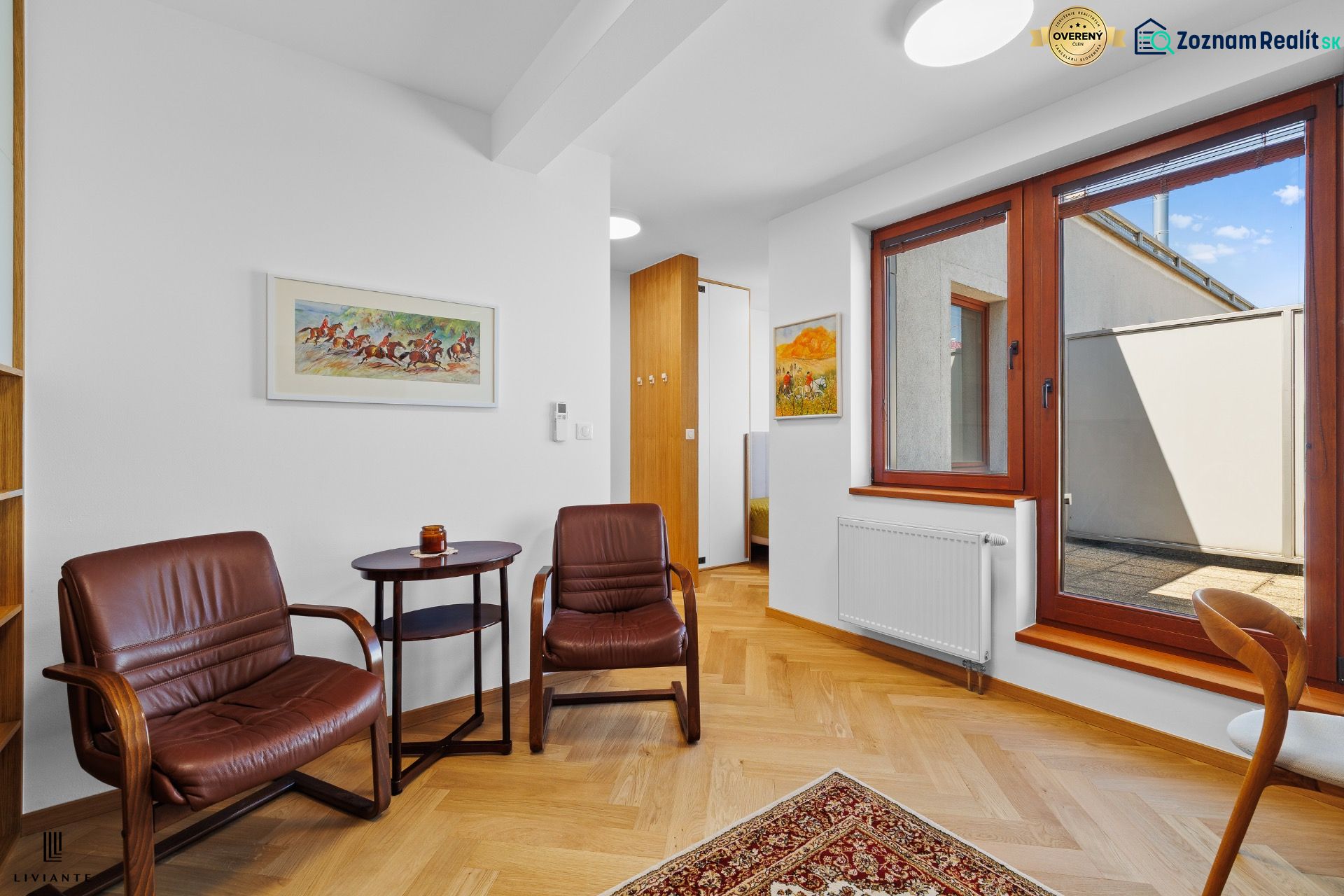 Interior of a 3-room apartment with a wooden decor floor and leather armchairs.