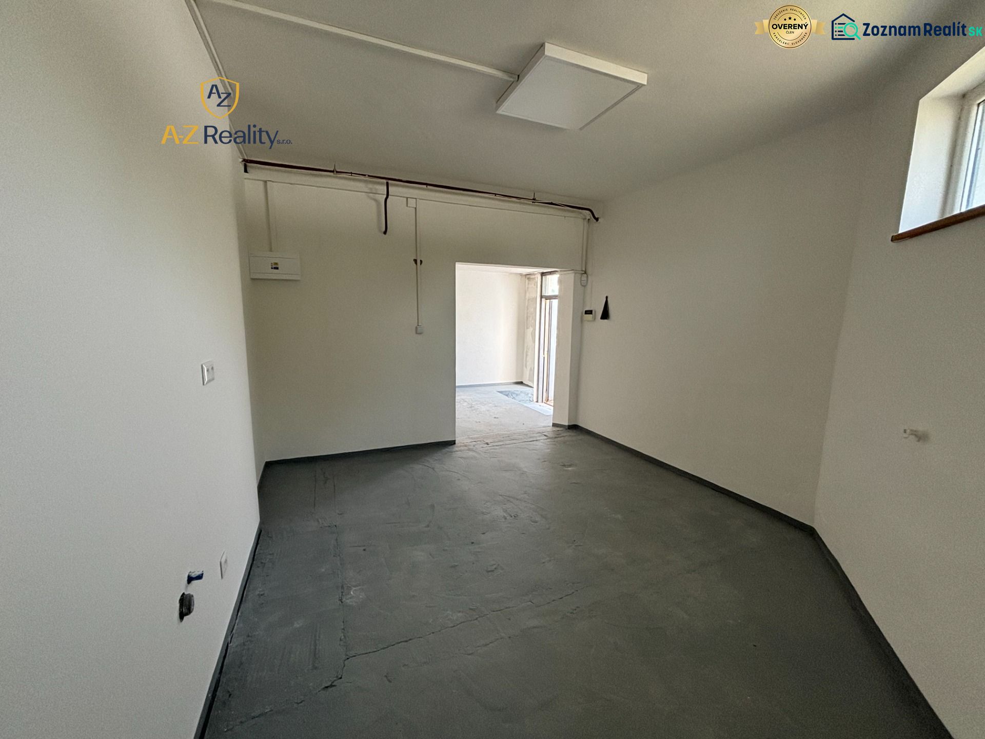 Interior space for rent with outlets and gray flooring in warehouses and halls.