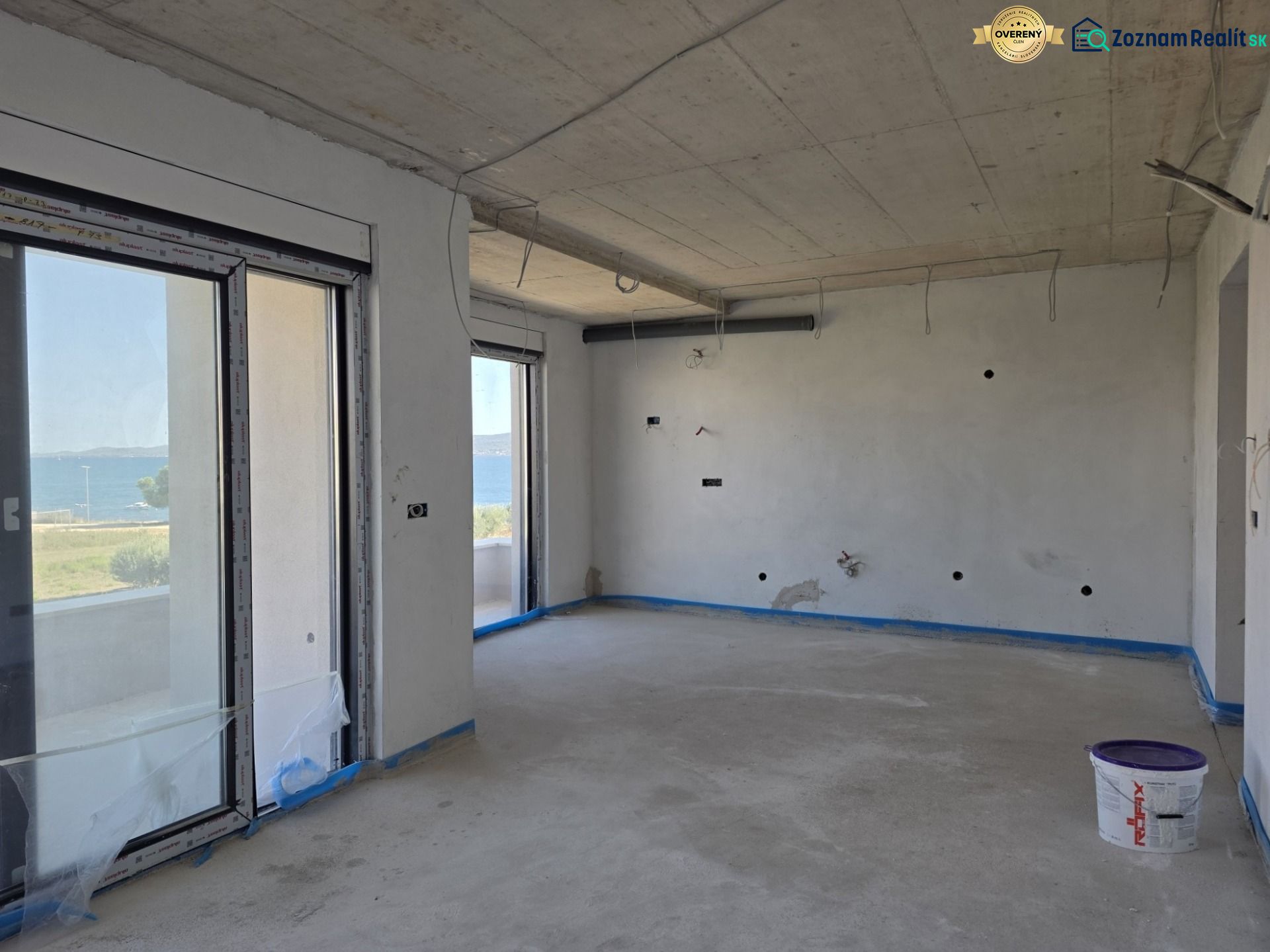 An empty interior of a 3-room apartment with a sea view, wooden decor flooring.