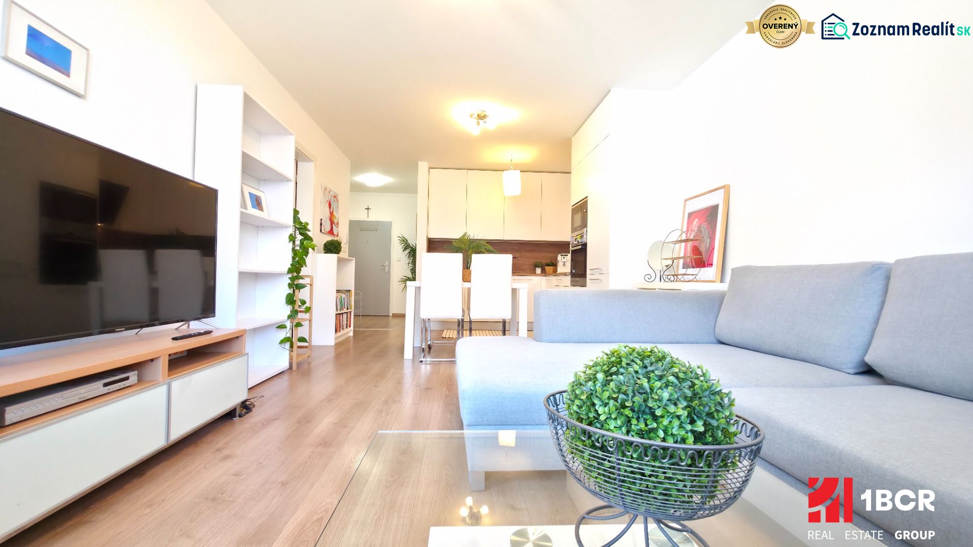 Living room with wood-patterned flooring in a 2-room apartment, TV and sofa.