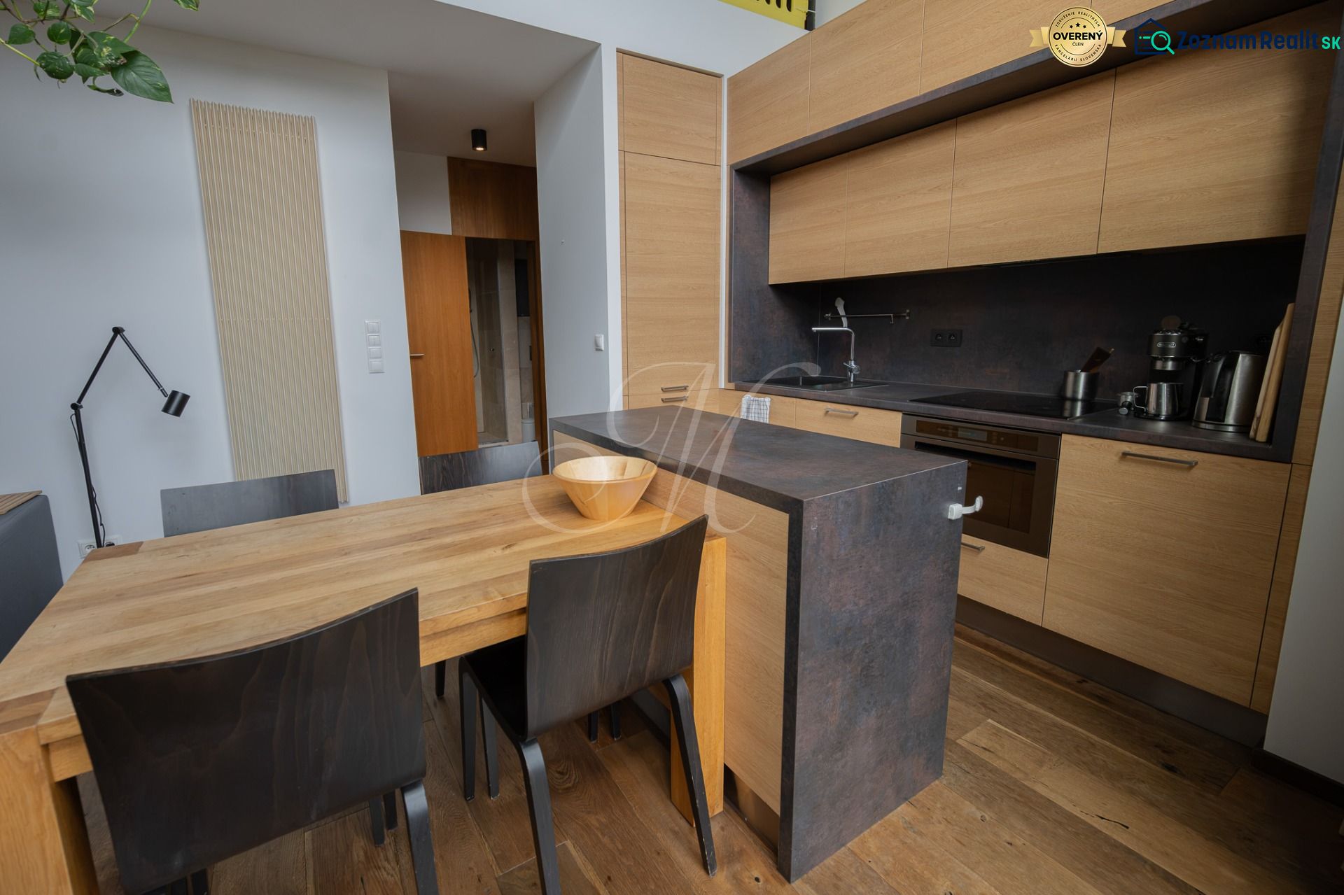 A kitchen in a 4-room apartment with wood-patterned floors and modern furniture.