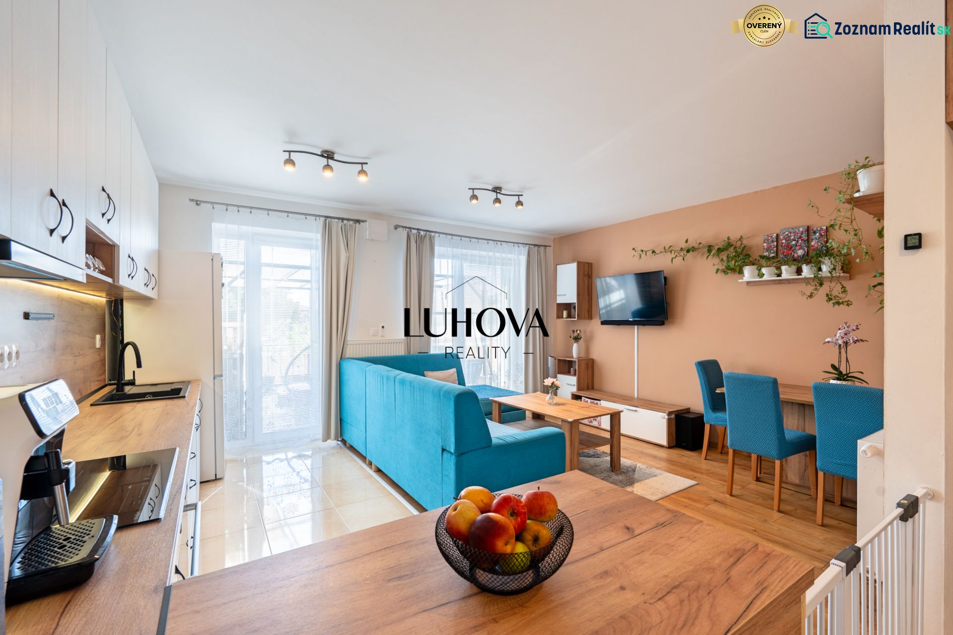 Open kitchen and living area in a 3-room apartment with a wooden decor floor.