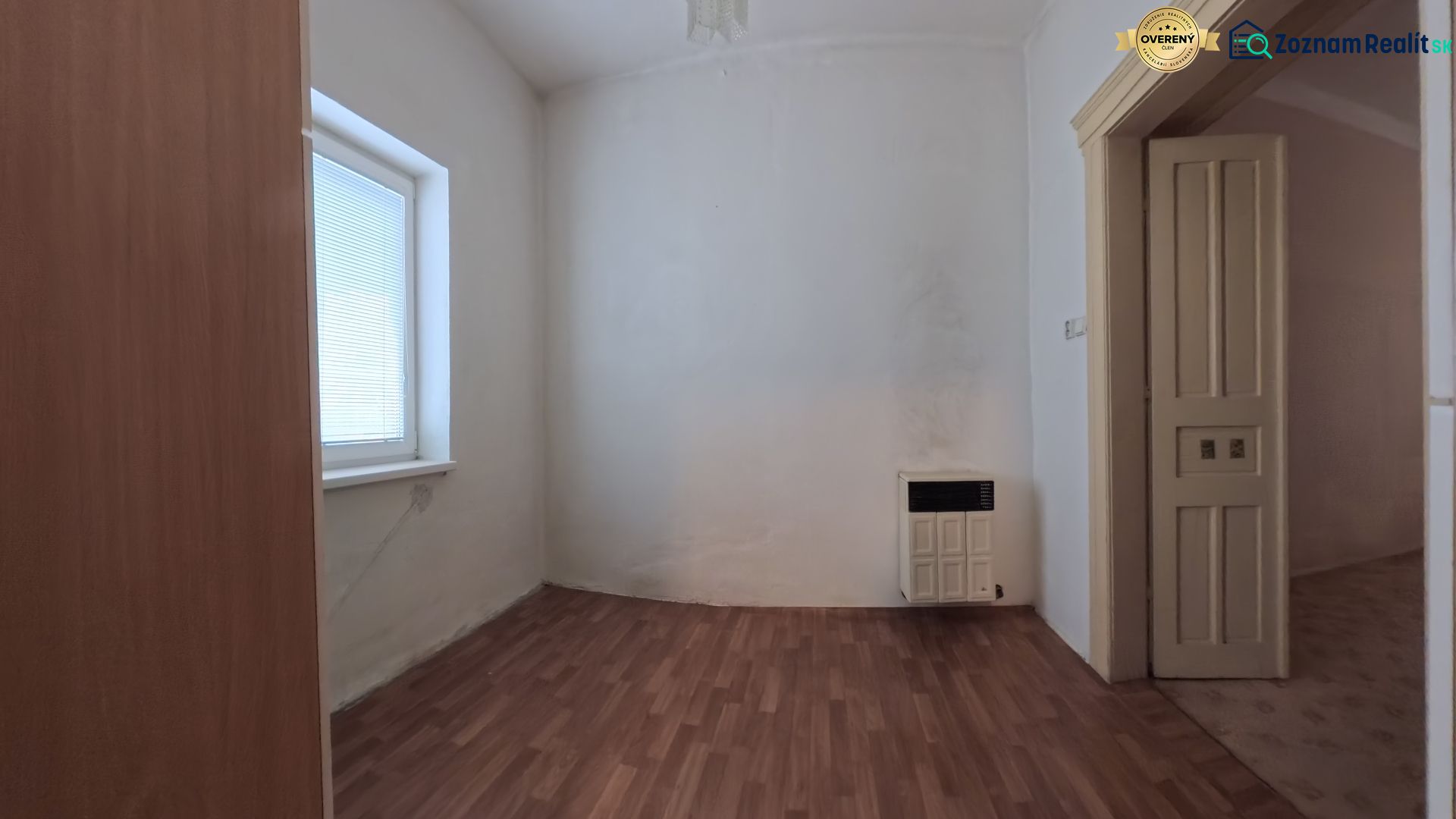 A room in a family house with a wooden decor floor and a heating unit.