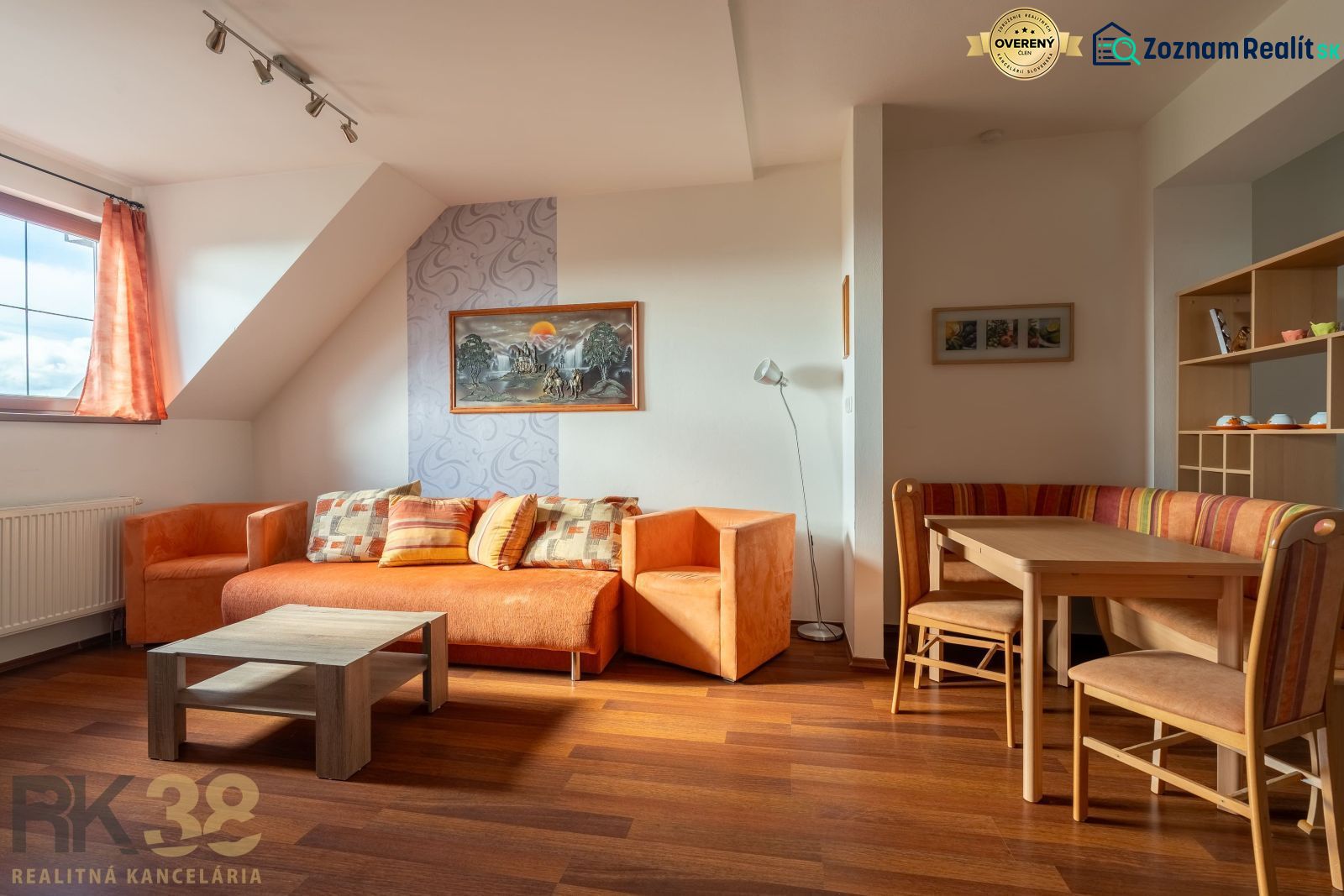 Living room in a two-room apartment with orange furniture and a wooden decor floor.