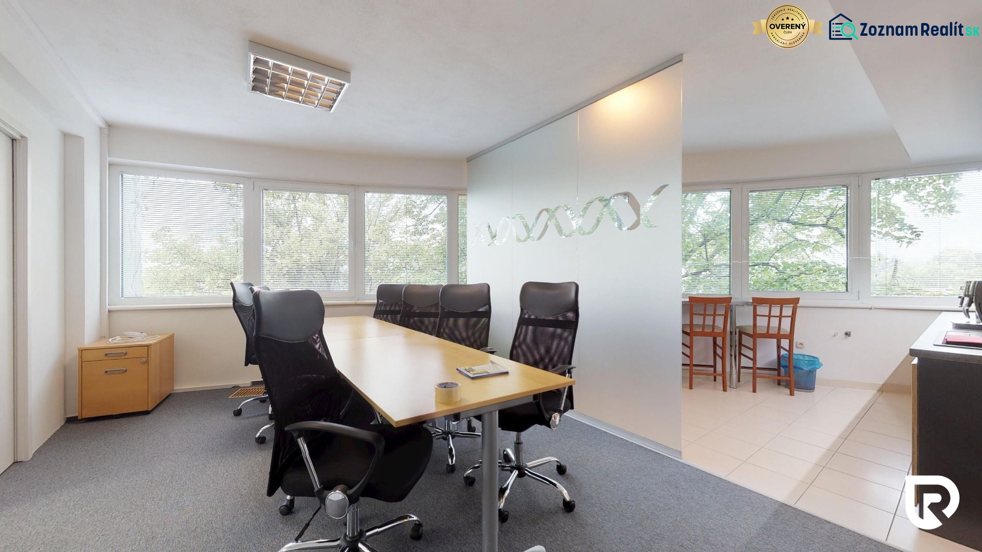Offices with a conference table, swivel chairs, and large windows with a view.