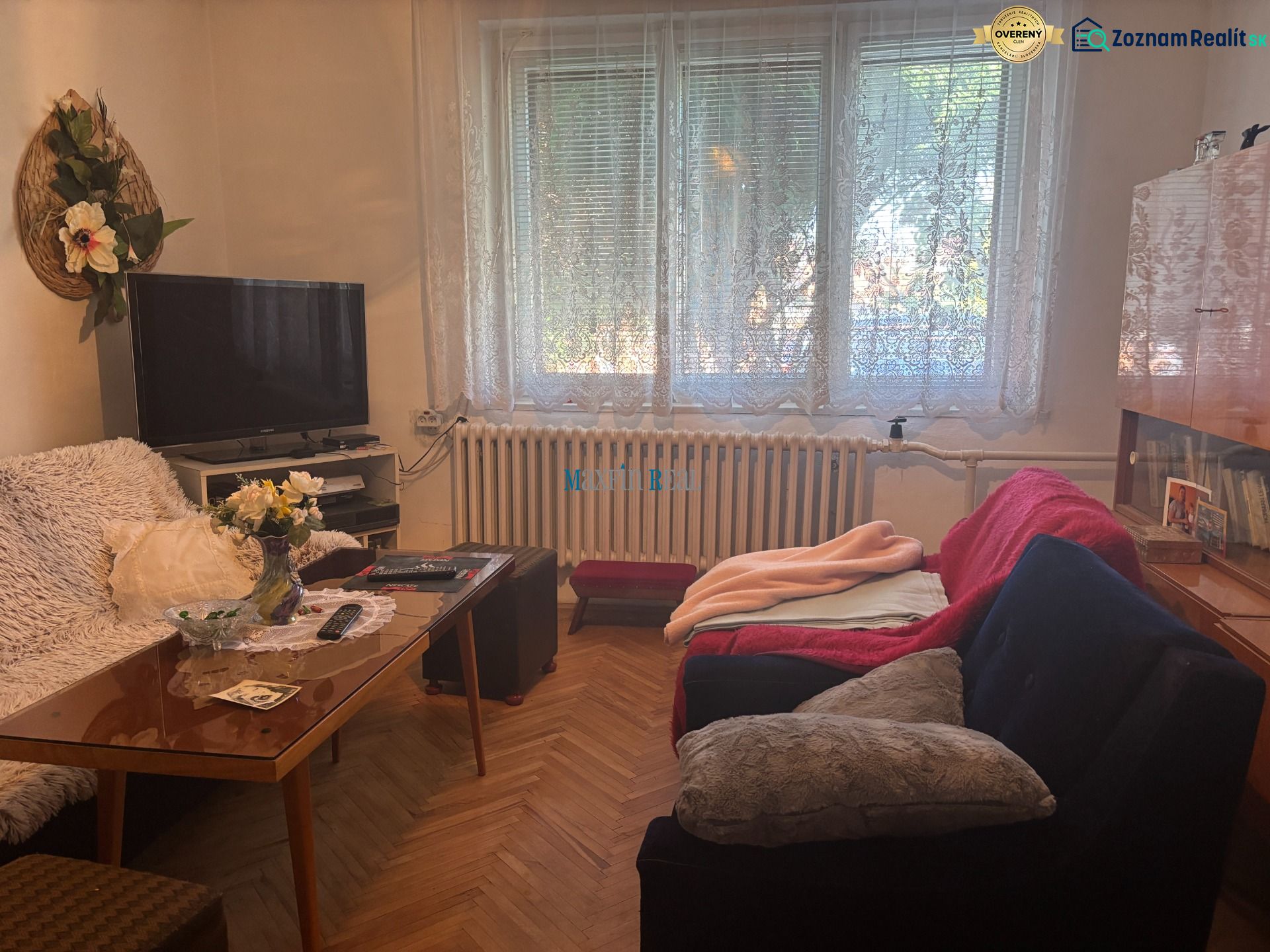 Living room in a family house with wooden floor decor, sofa, and television.