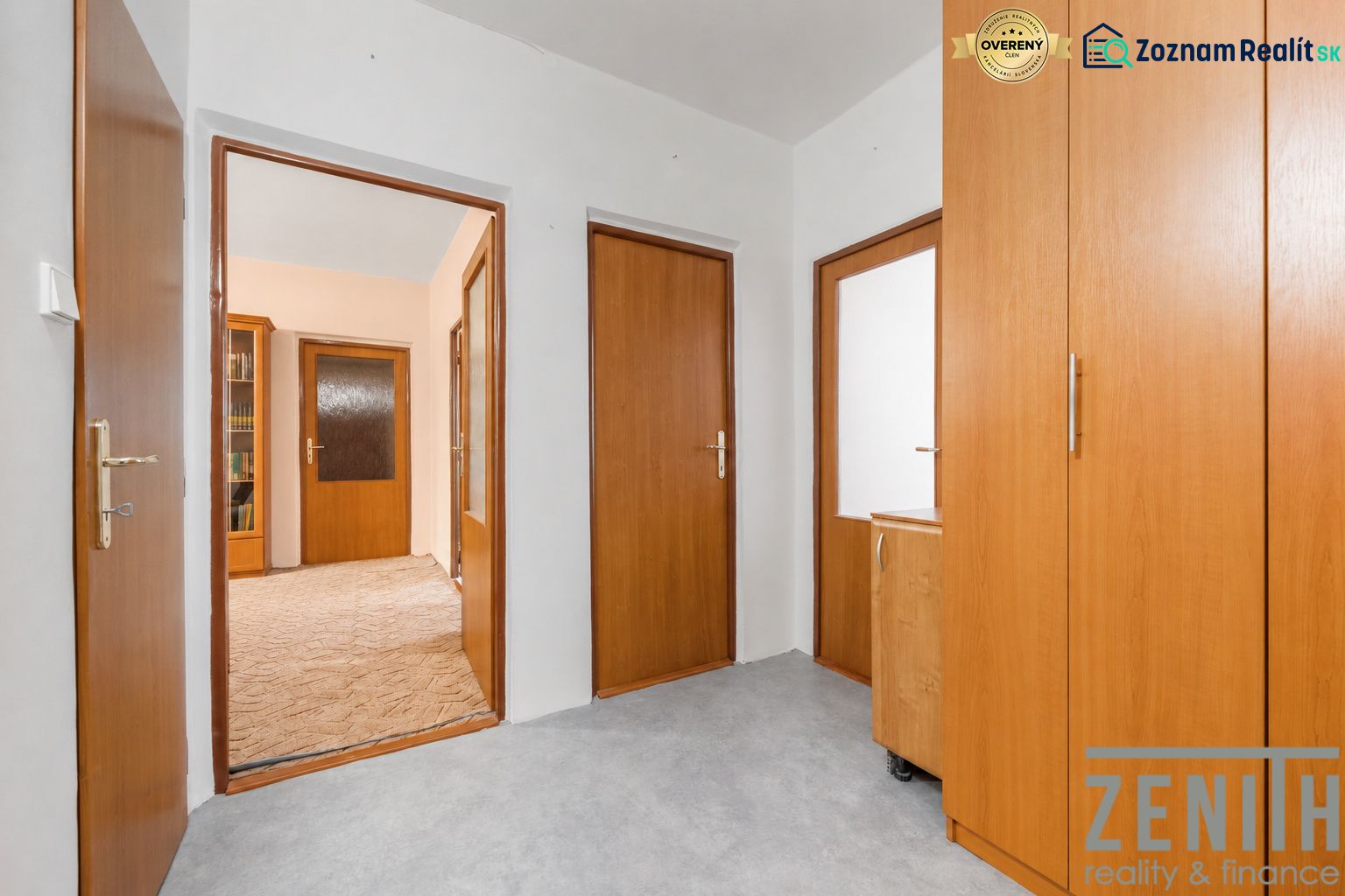 A hallway in a 4-room apartment with wooden doors and built-in wardrobes.