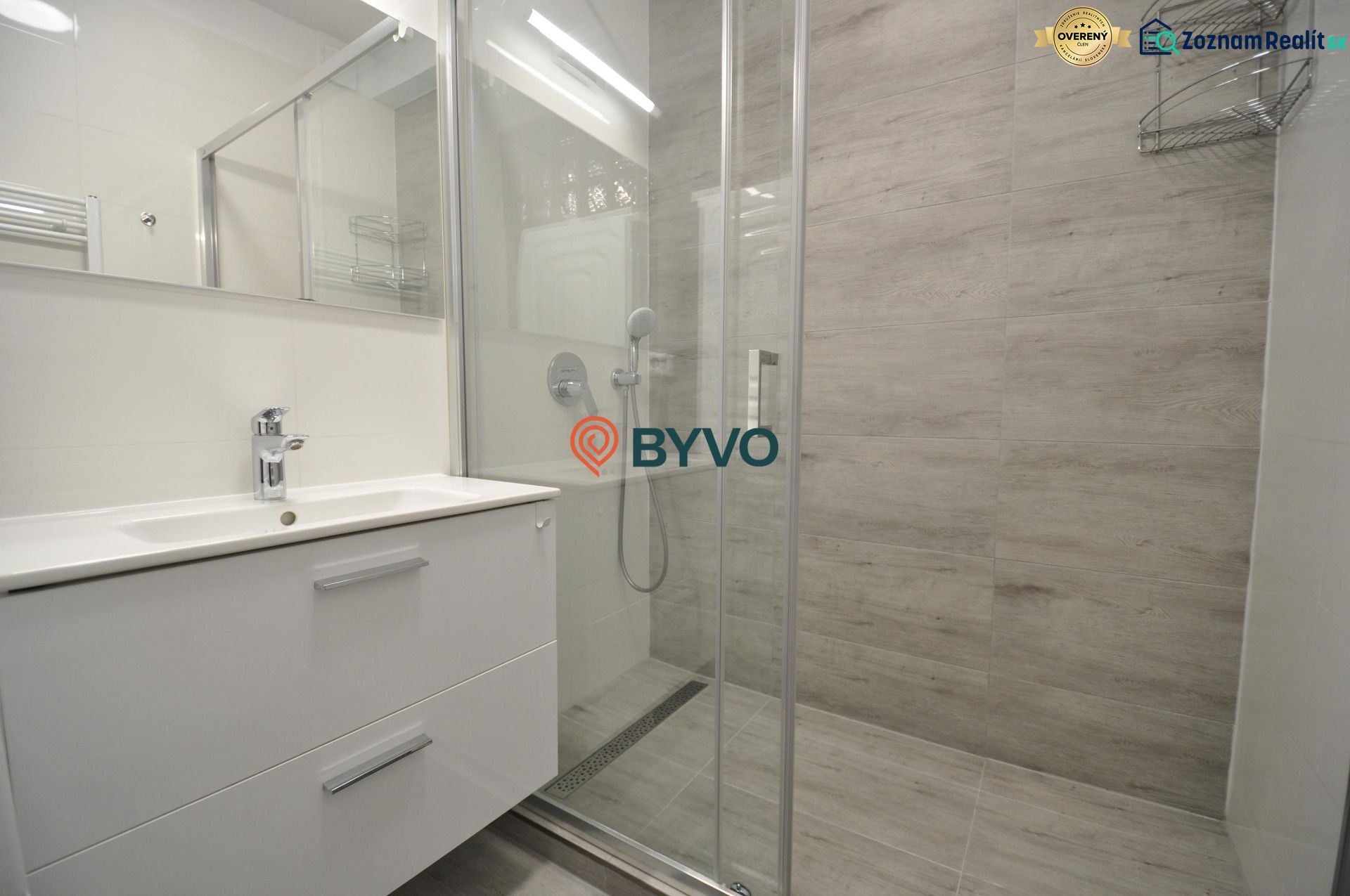 Shower corner with a sink and modern tiles in a 2-room apartment.