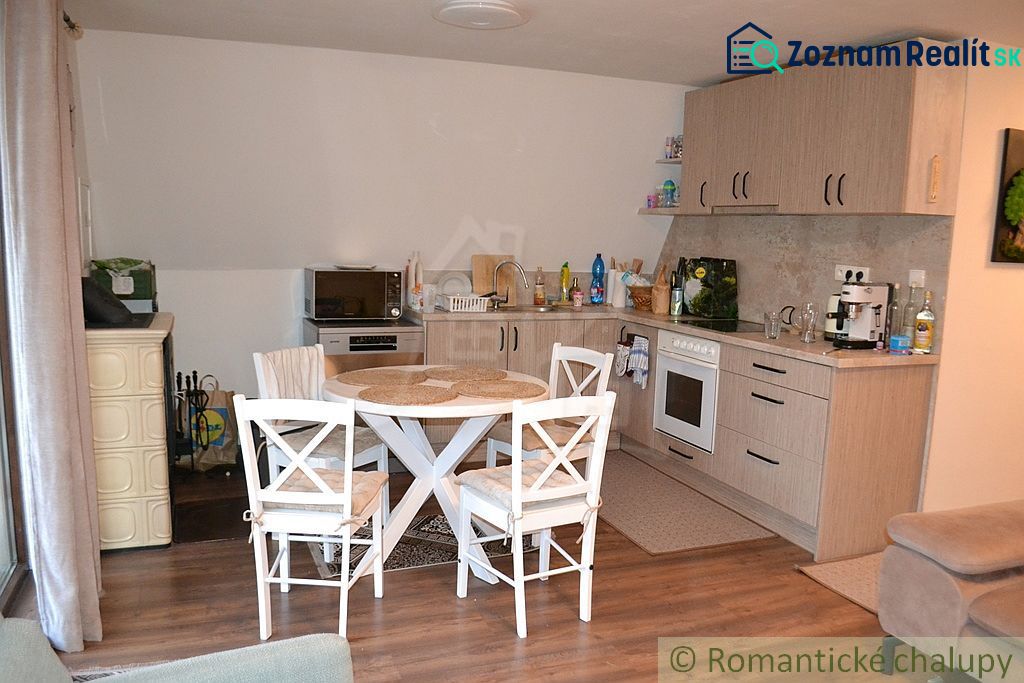 A kitchen in a cottage with wooden decor and a dining table.